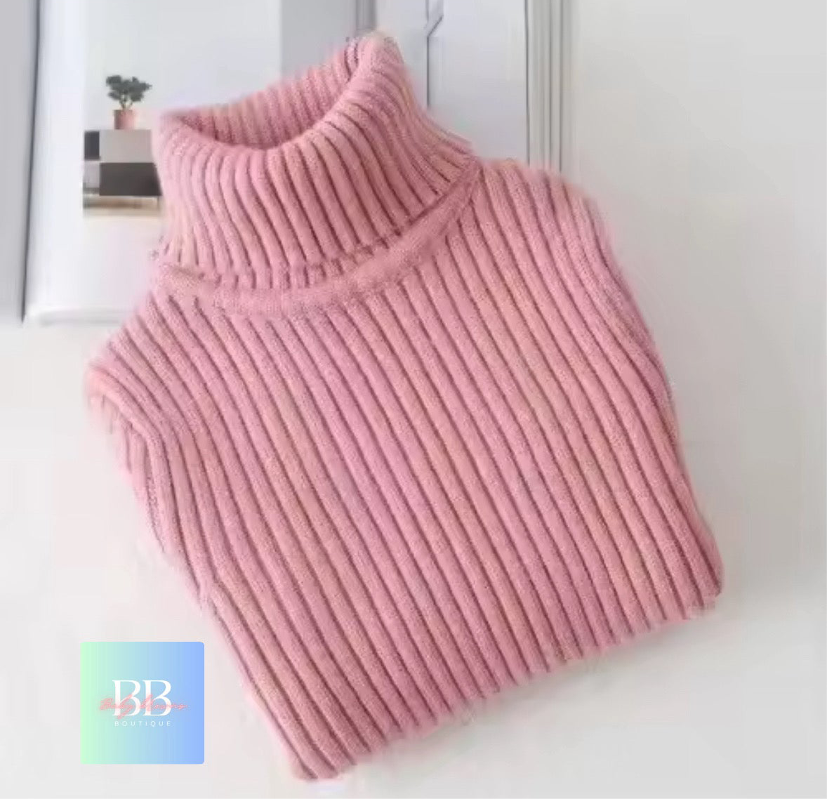 Pink ribbed sweater on a white background