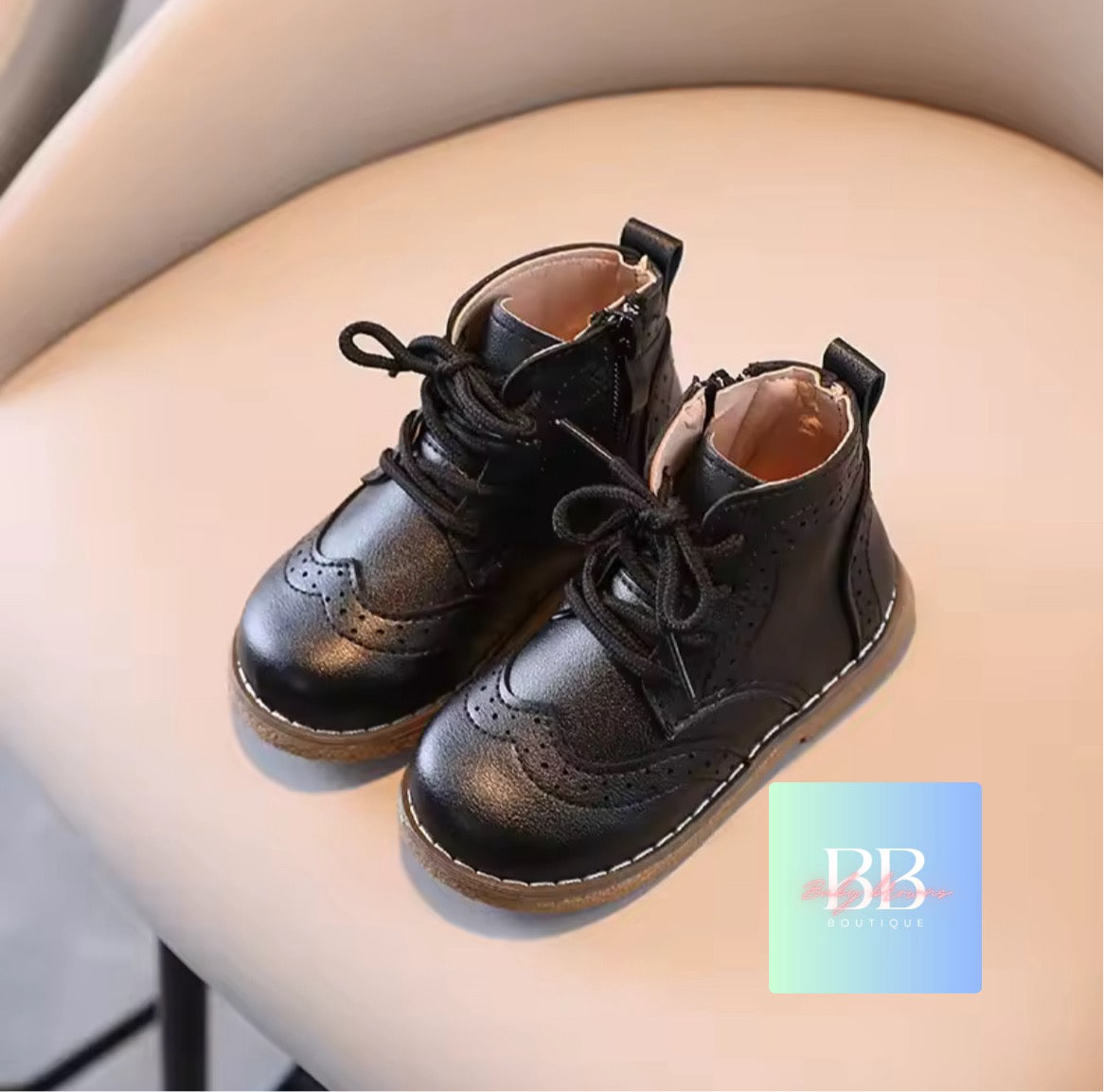 Black leather boots on a person's leg with a visible brand logo.