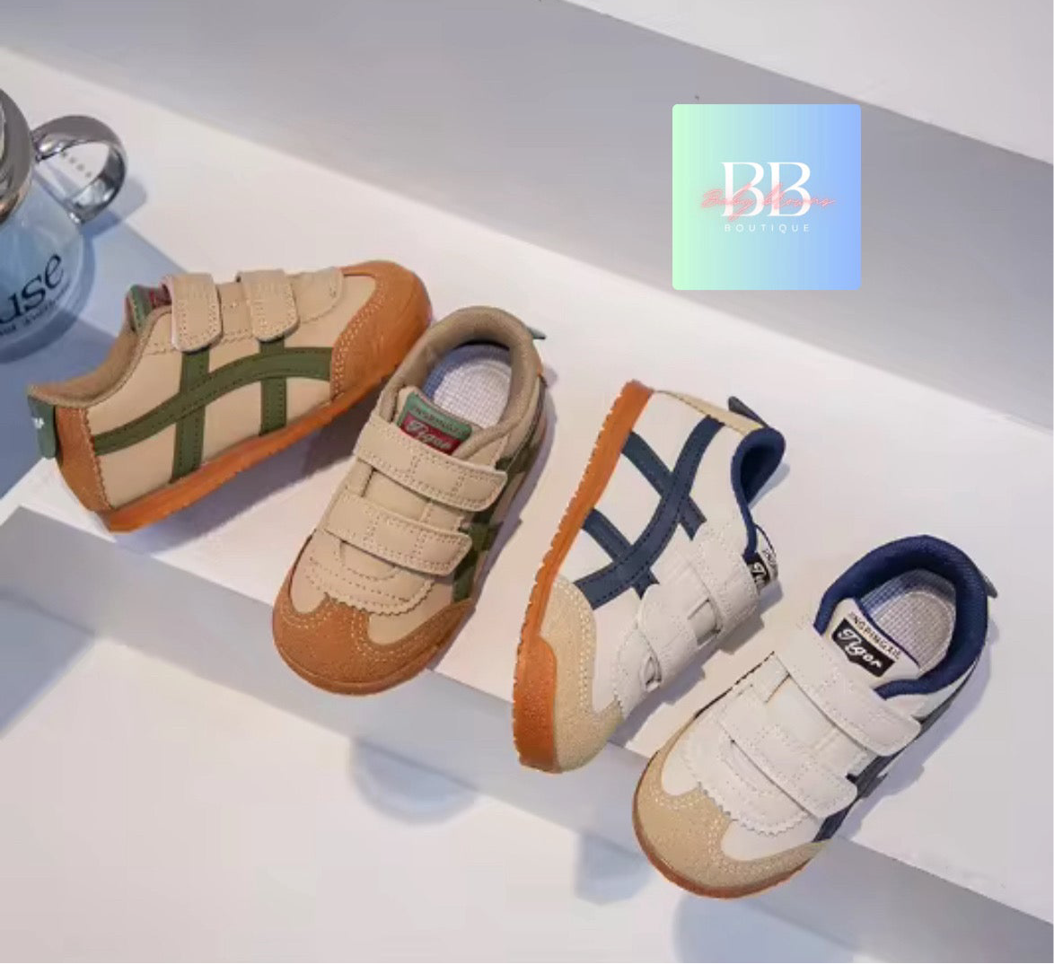 Three pairs of children's shoes on a white surface with a brand logo in the corner.