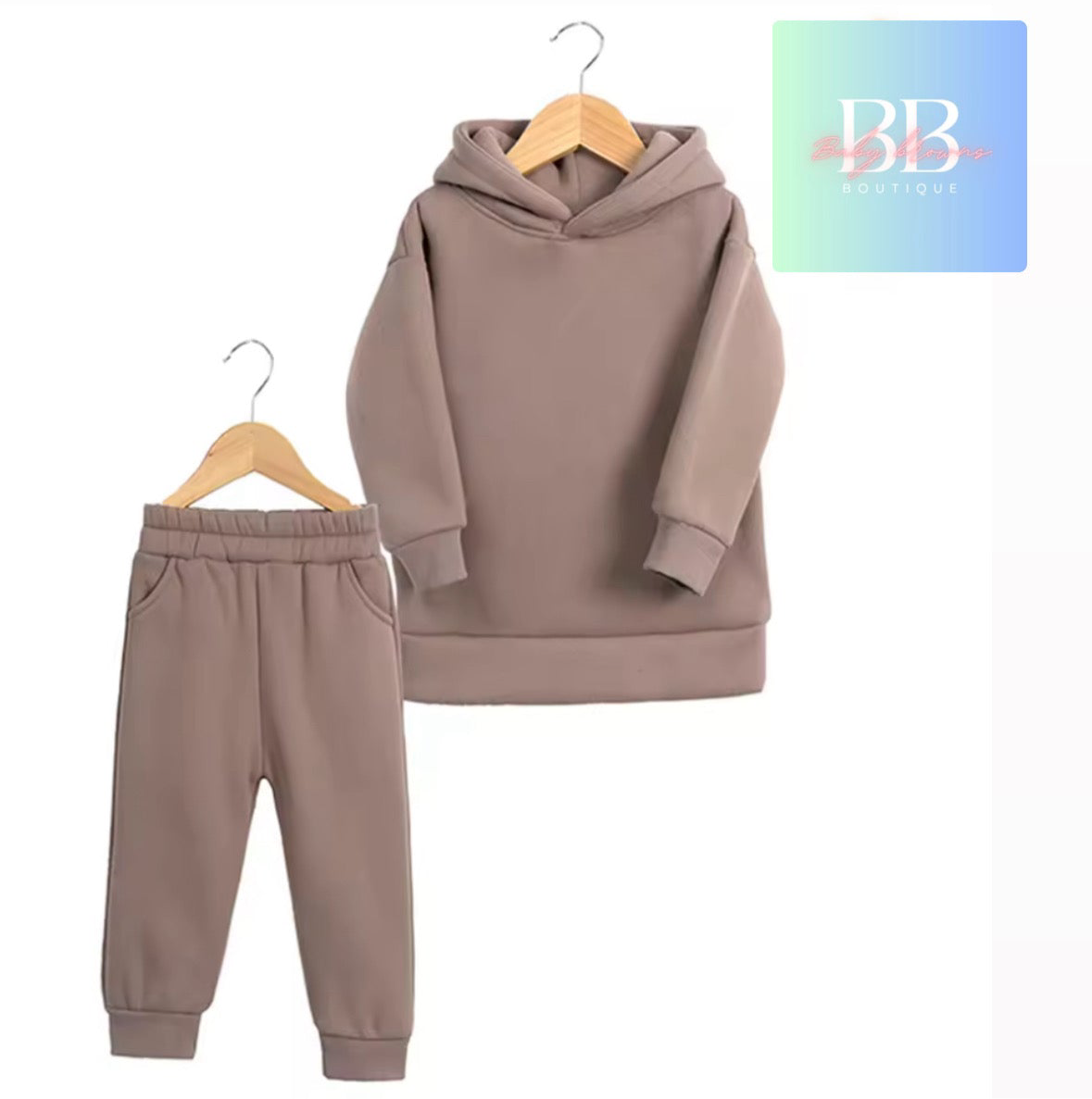 Brown hoodie and pants set on hangers with a brand logo in the corner.