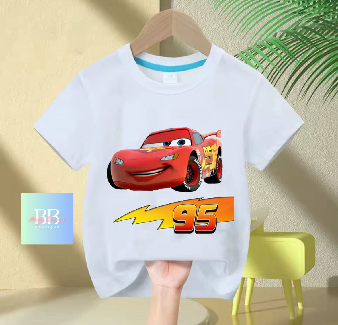 White t-shirt with a red car graphic and '95' on a beige background