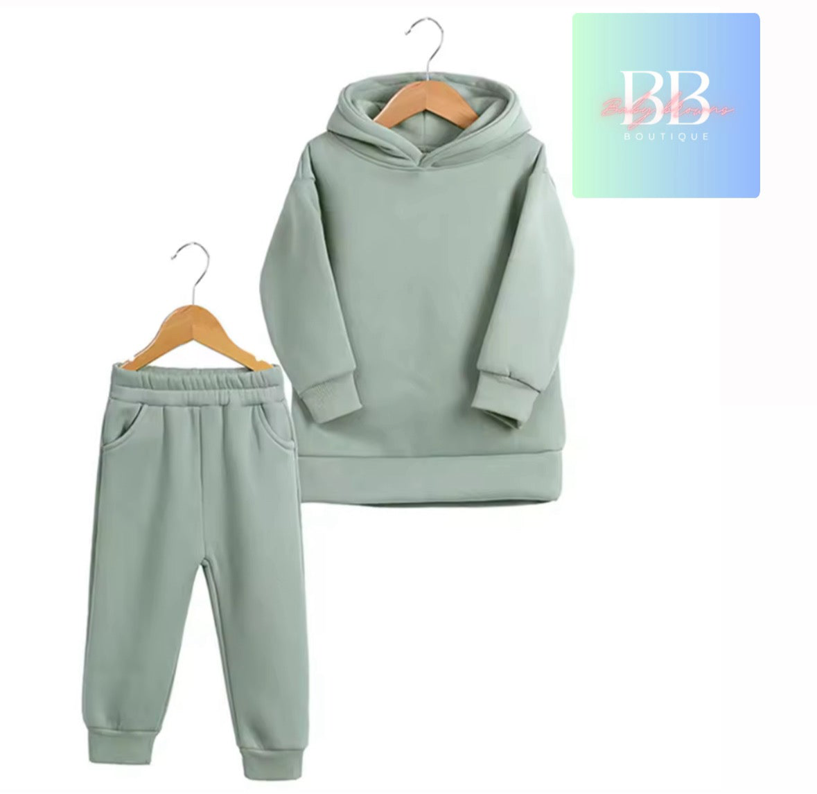 Light green hoodie and jogger set on hangers with a visible brand logo.