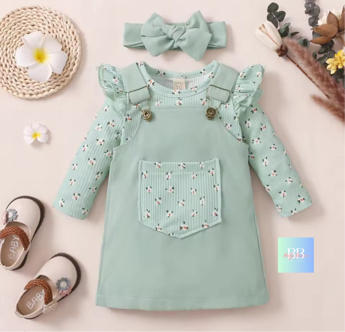 Mint green dress with floral pattern, matching headband, and shoes on a light background