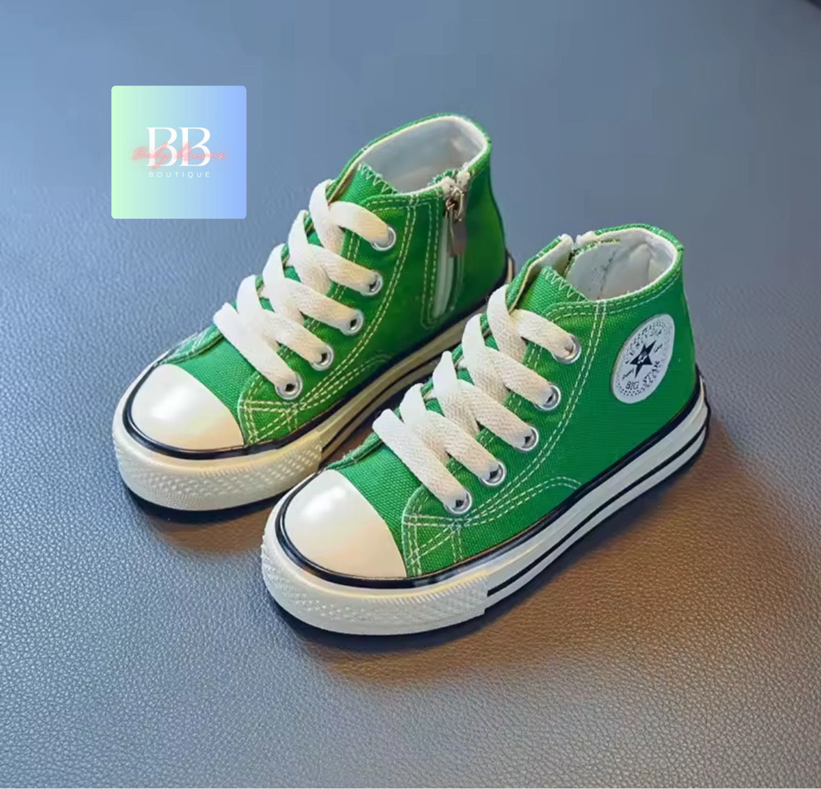 Green high-top sneakers with white laces on a blue surface, featuring a brand logo in the corner.