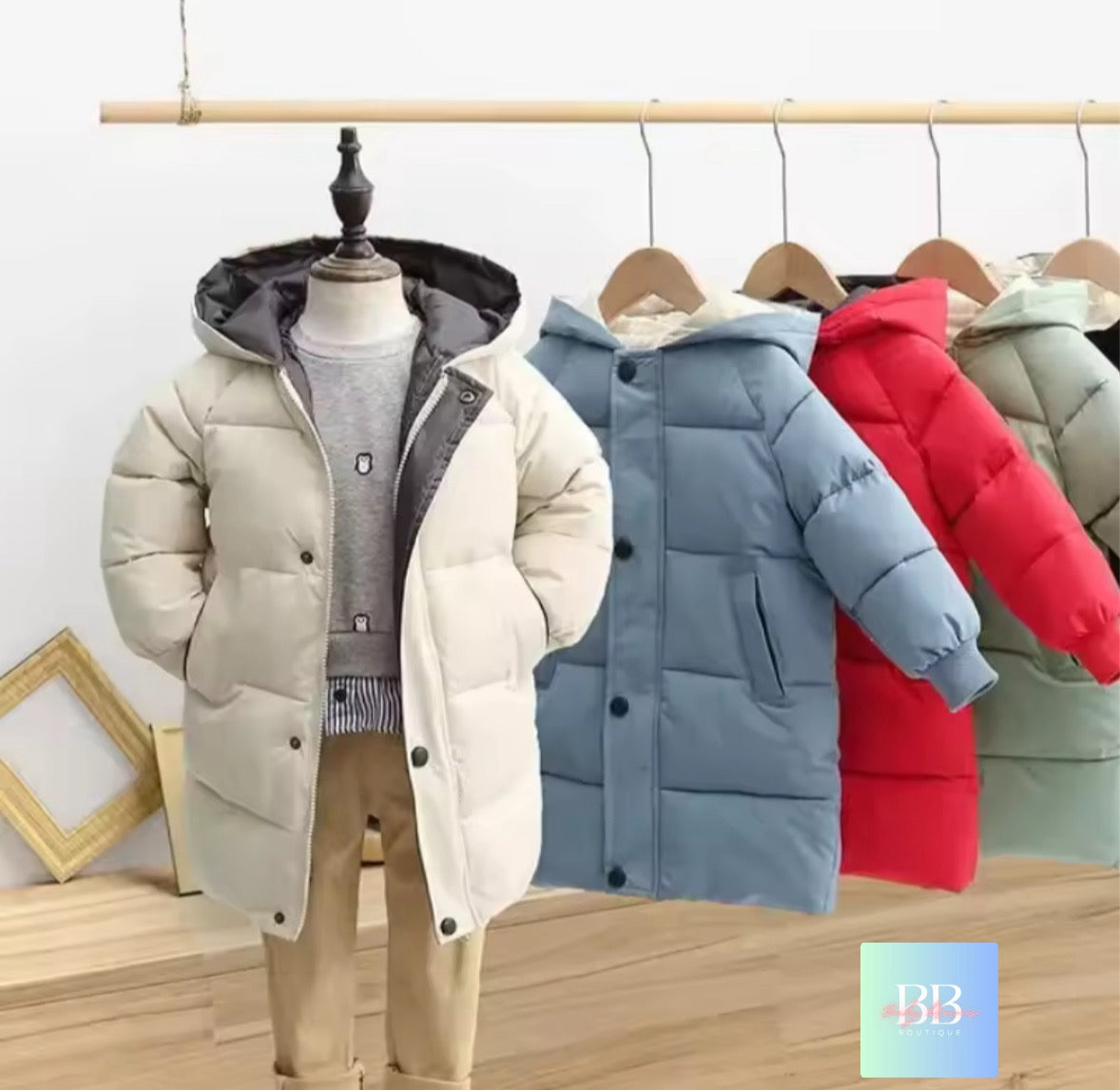 Collection of puffer jackets in various colors on a wooden floor with a white wall background.