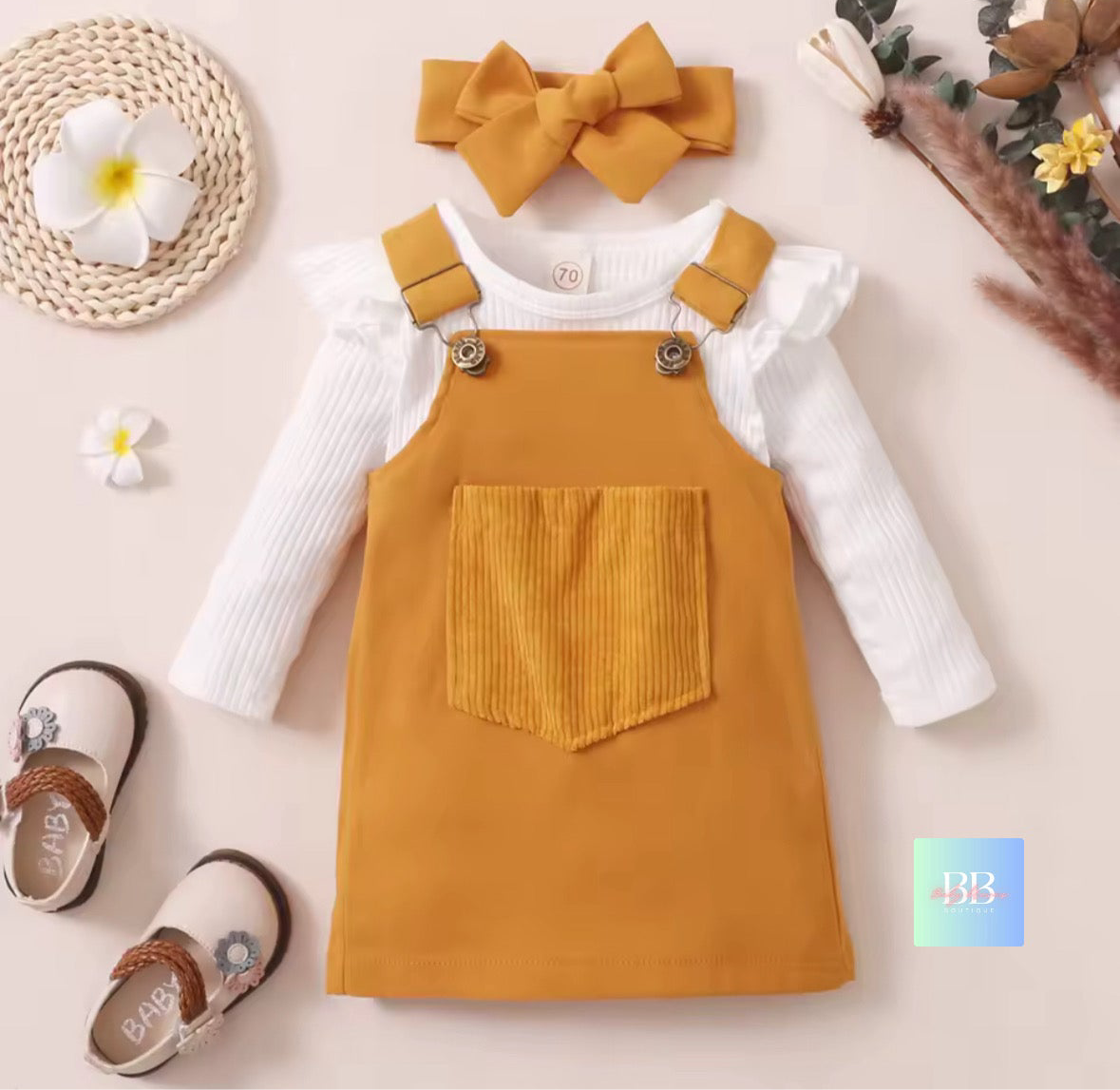 Yellow dress with white shirt, headband, and shoes on a light background