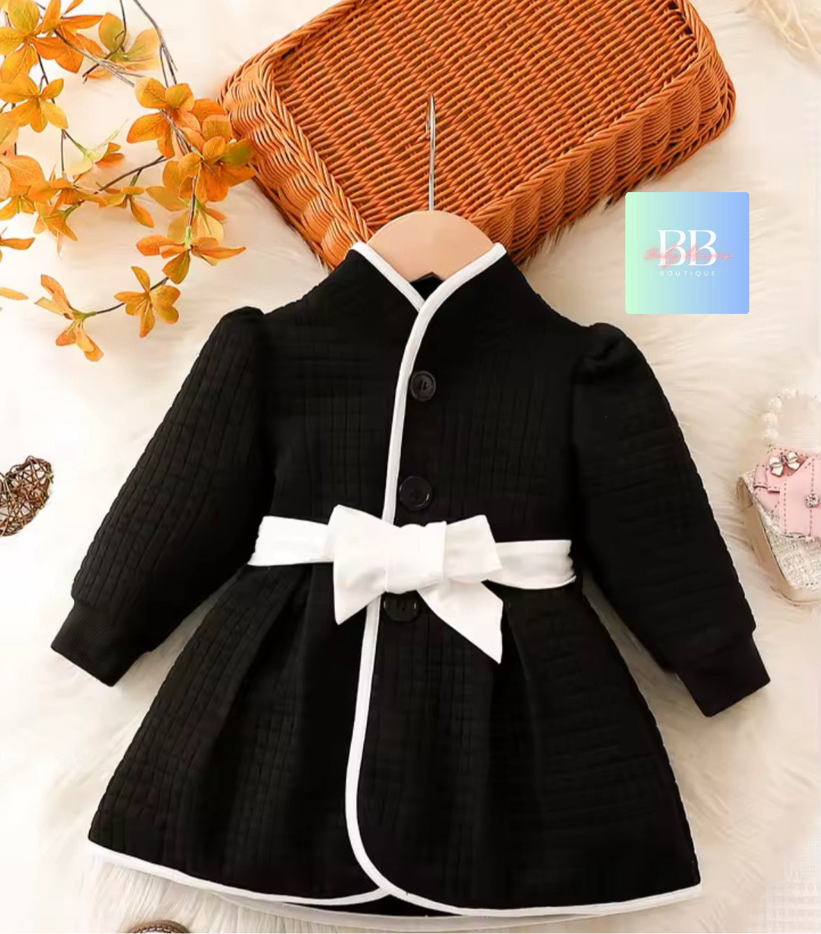 Black dress with a white bow on a light background