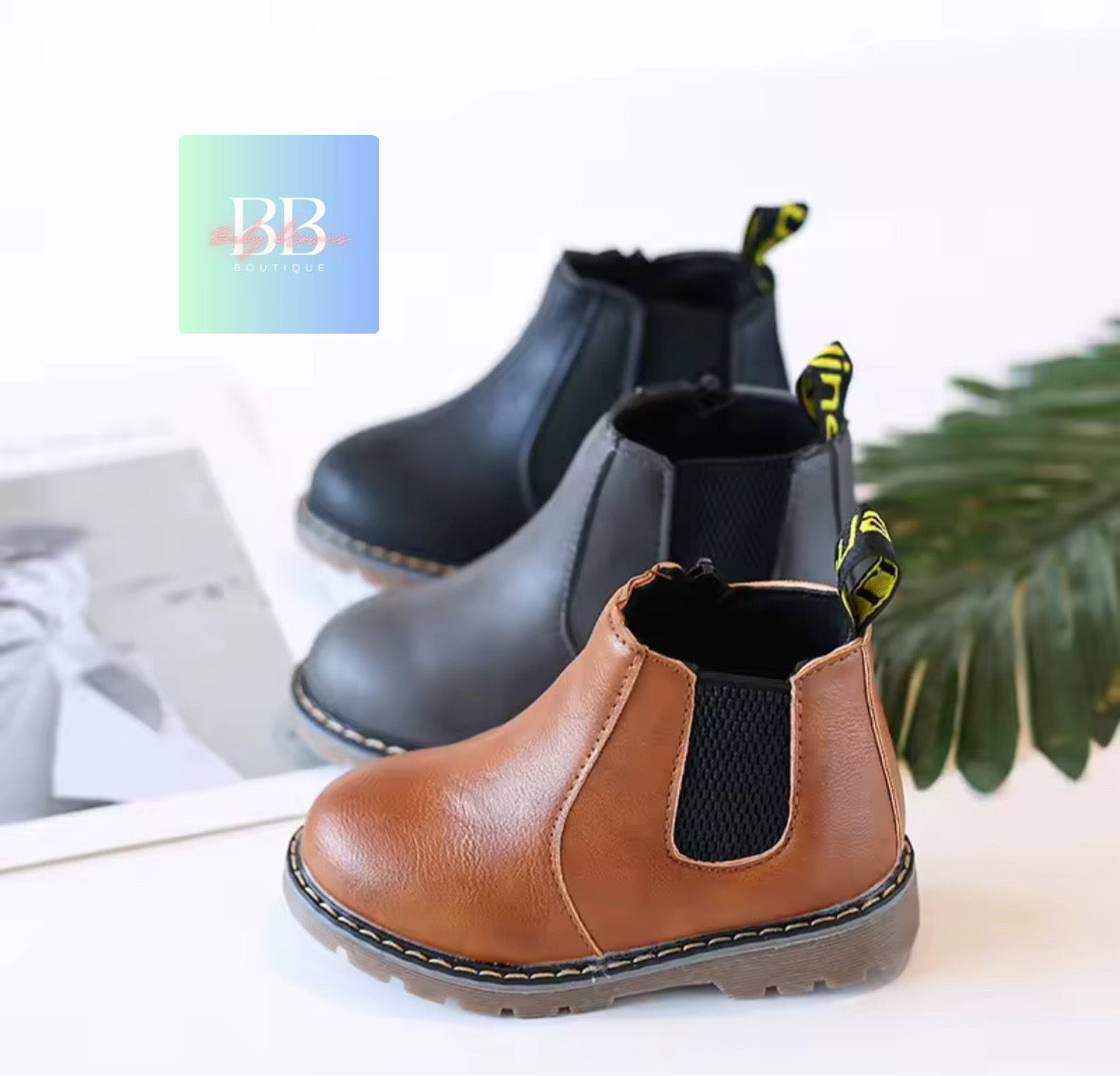 Pair of brown and black children's boots with a brand logo in the corner.