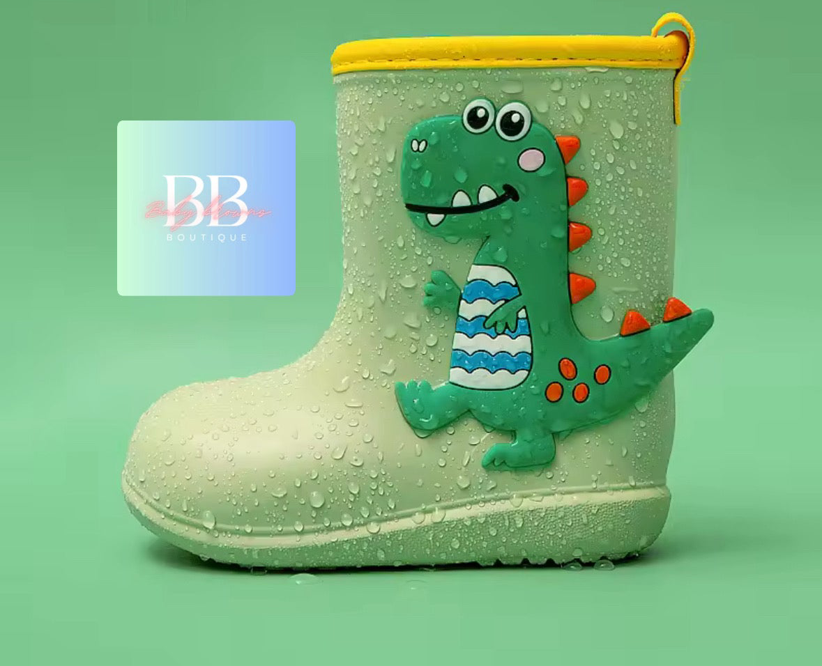 Children's rain boot with dinosaur design on a green background