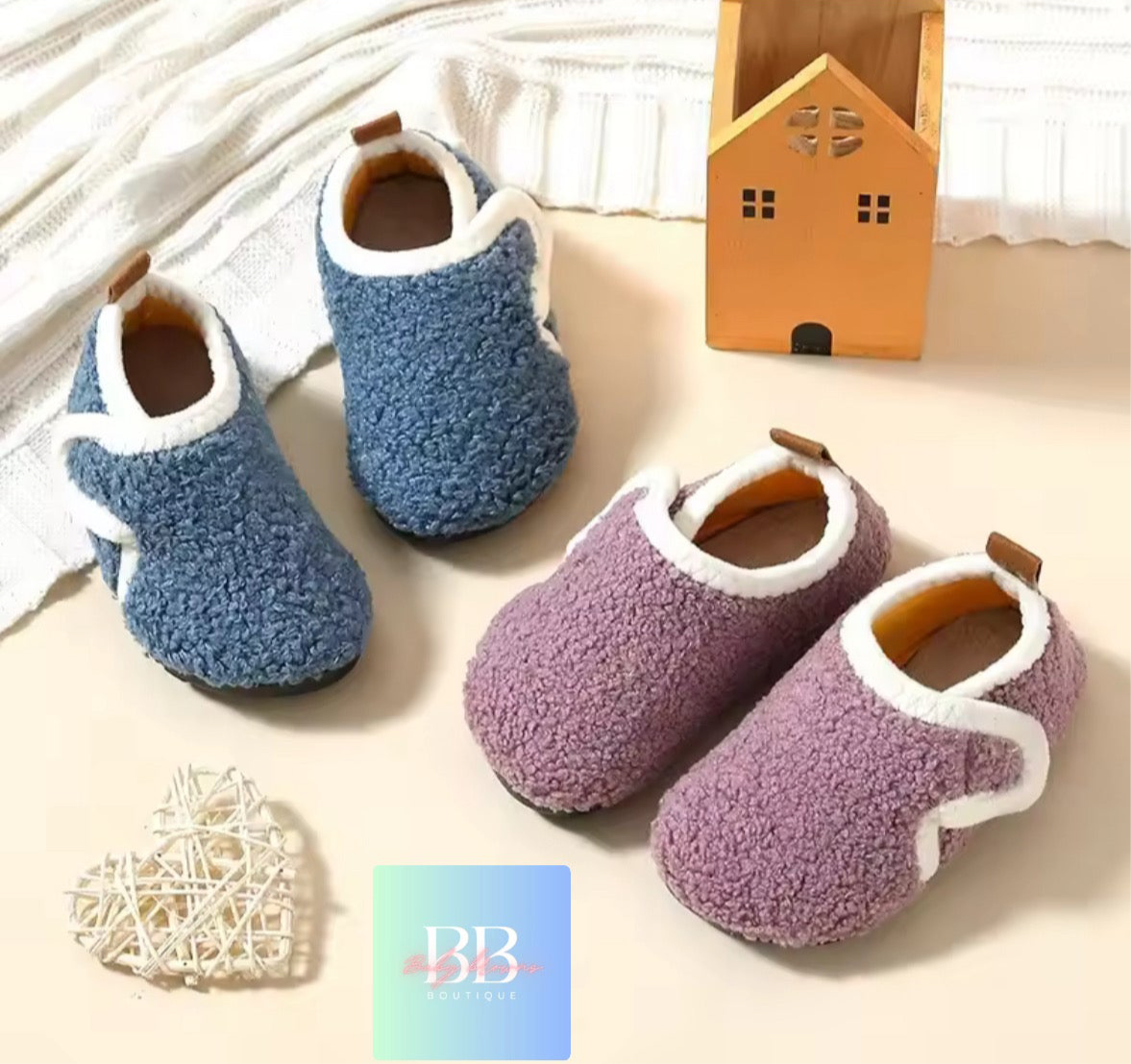 Pair of blue and purple fuzzy slippers on a soft surface with decorative items.