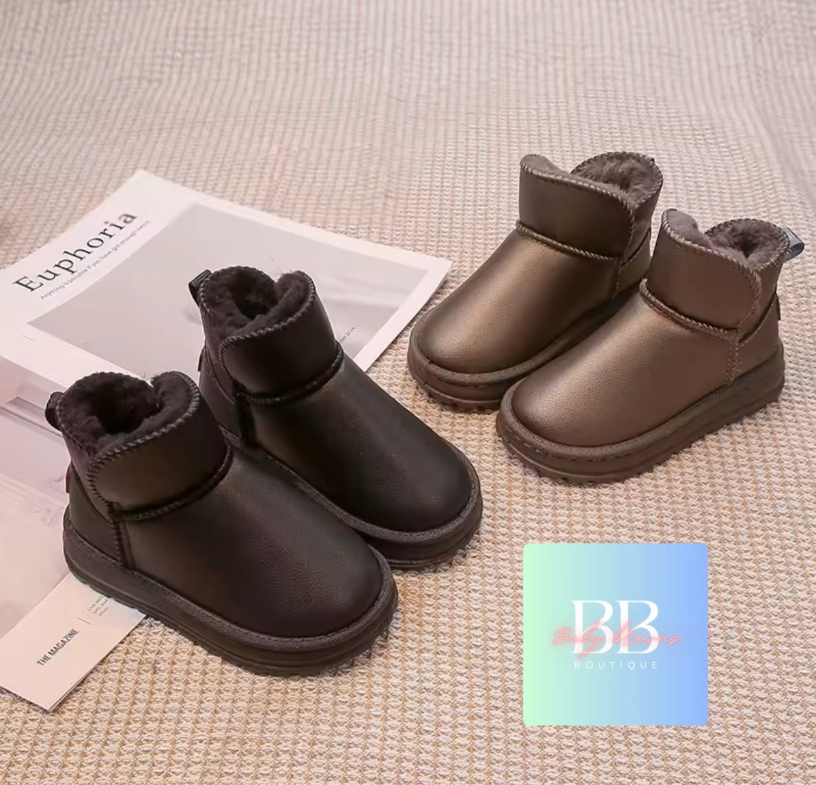 Pair of brown winter boots with fluffy lining on a textured surface, with 'BB' logo in the corner.