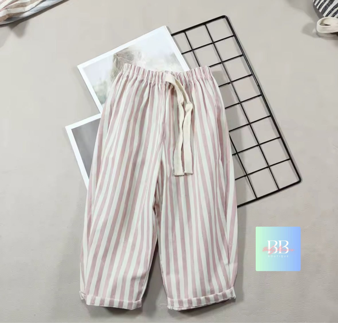 Striped pants on a light gray surface with a grid pattern