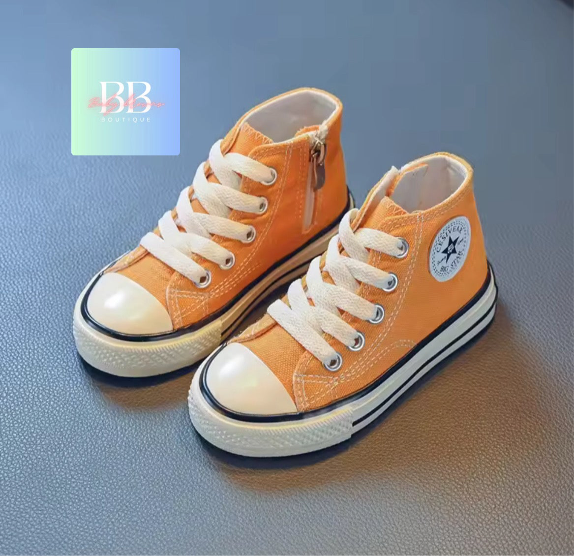 Pair of orange high-top sneakers with white laces on a blue background
