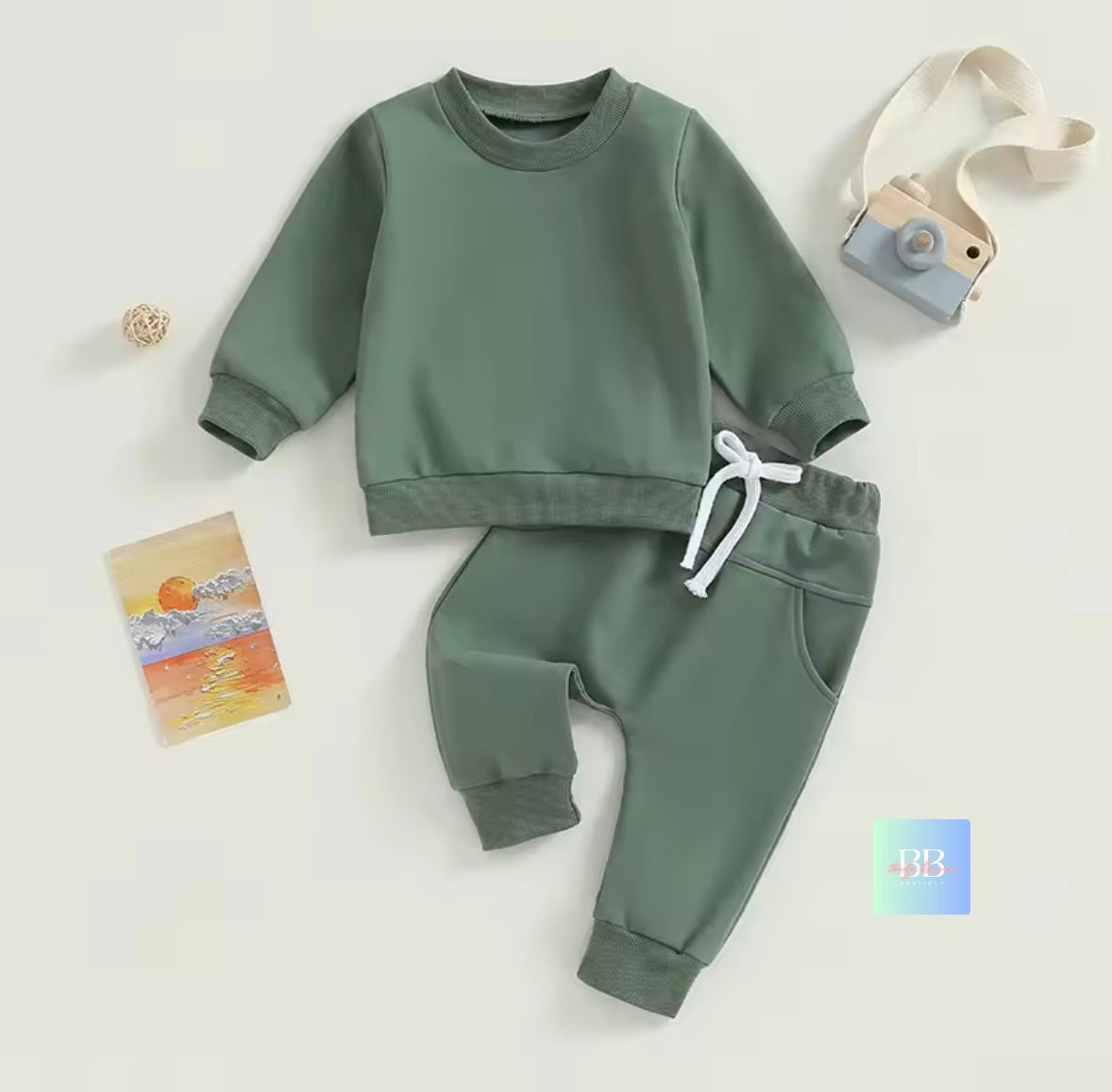 Green children's sweatshirt and pants set on a white background