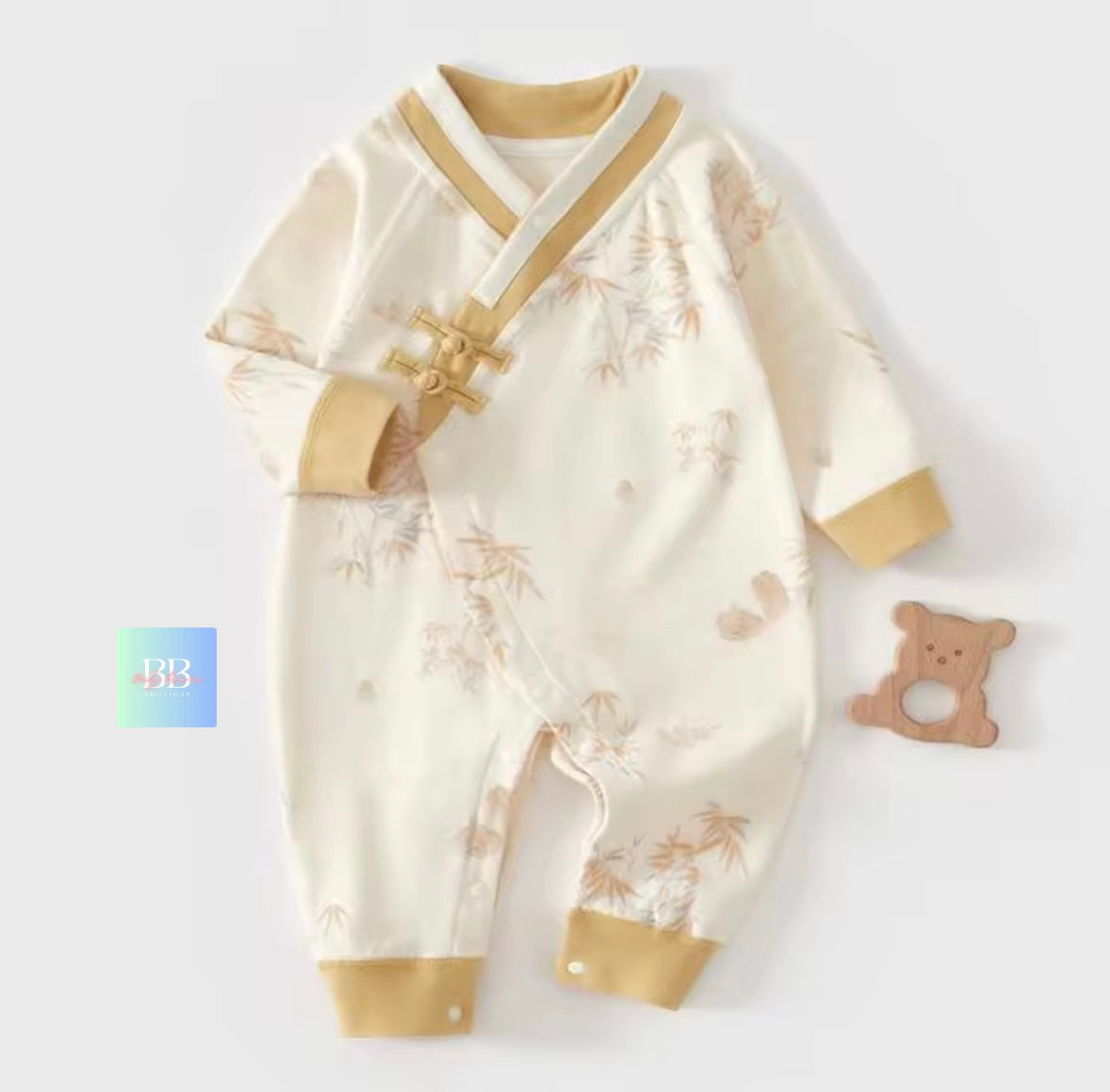 Baby romper with gold accents on a white background