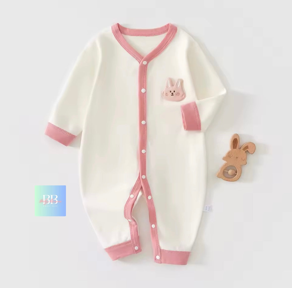 Baby onesie with pink accents and a bunny design on a white background