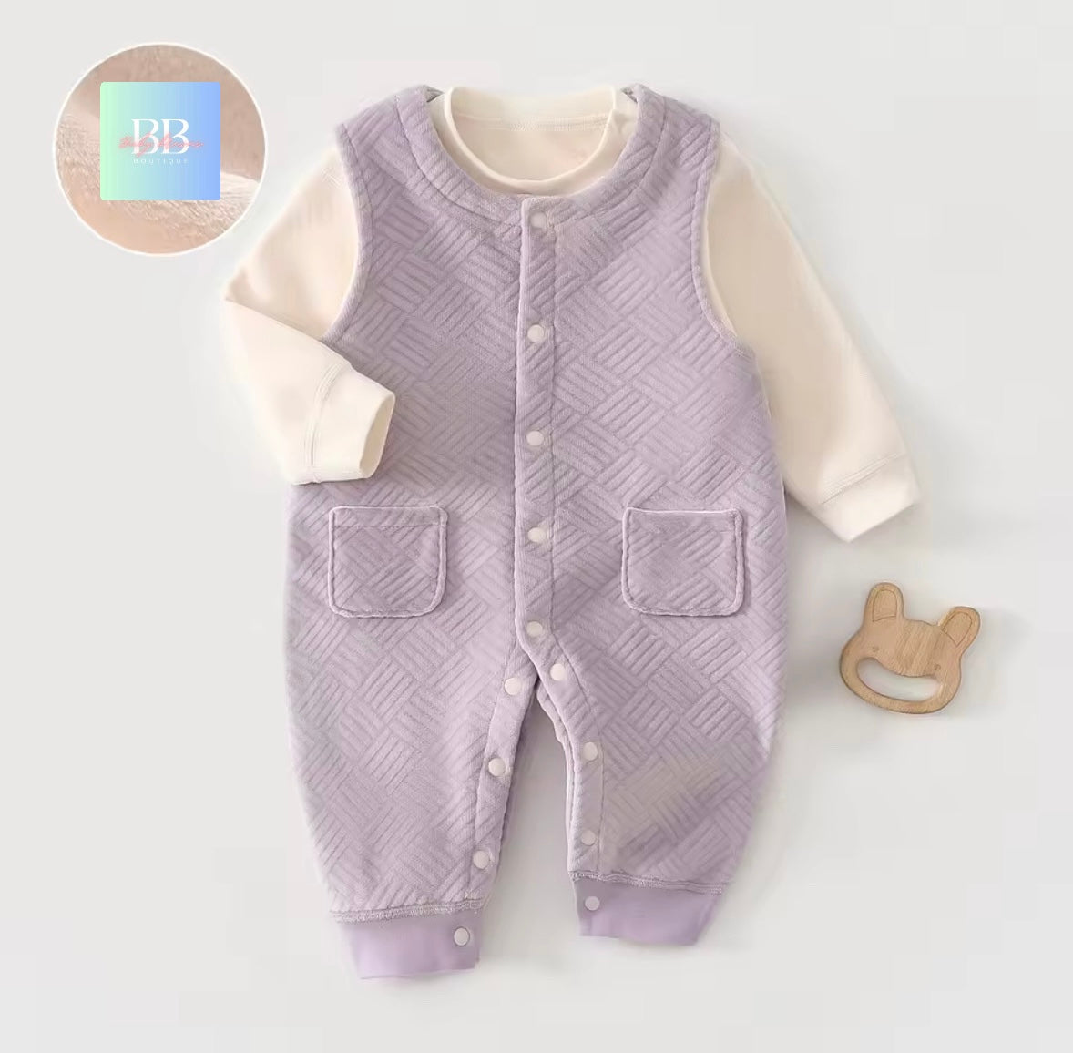 Purple quilted baby romper with white sleeves on a light gray background