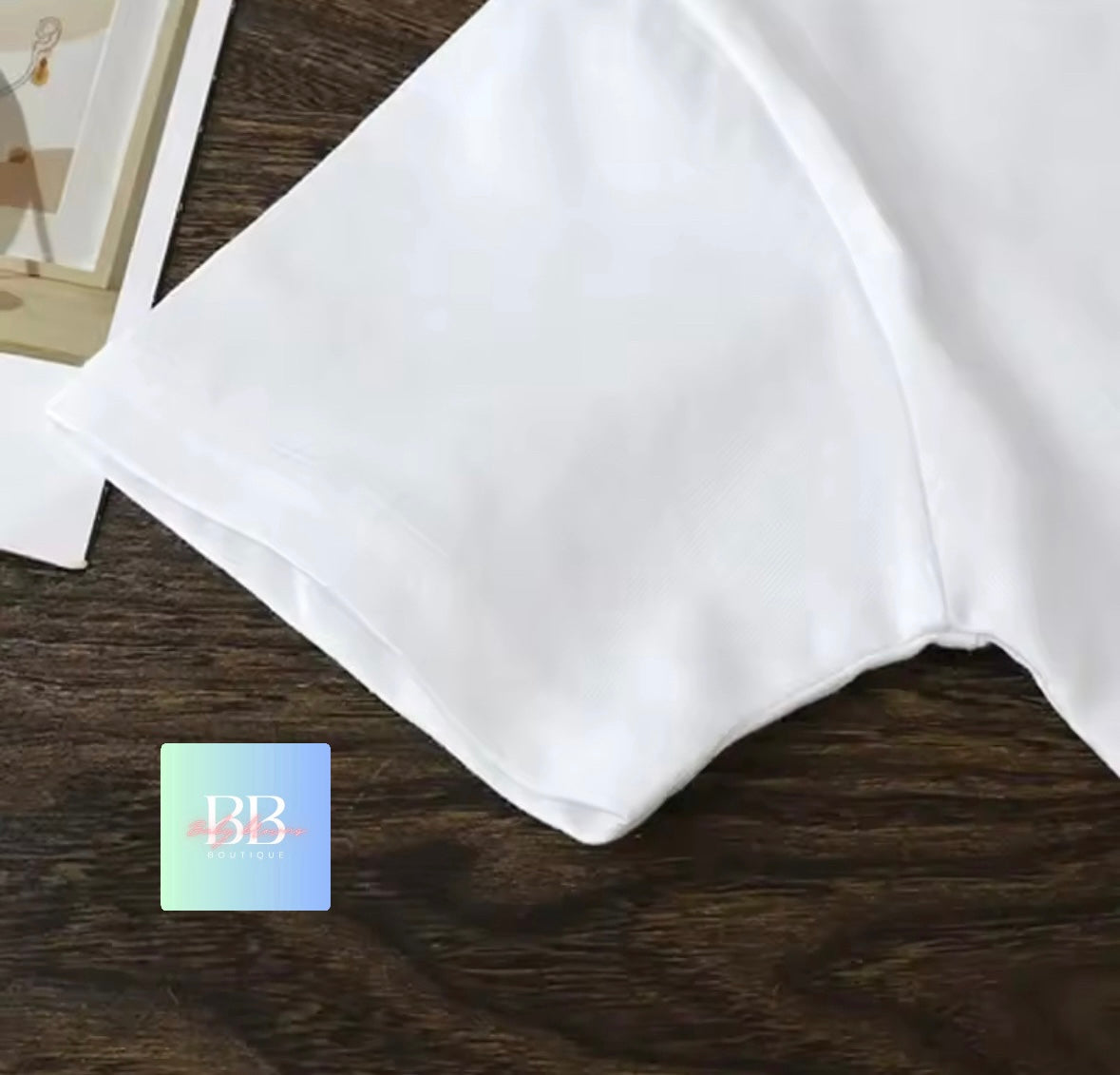 White fabric on a brown surface with a brand logo in the corner.