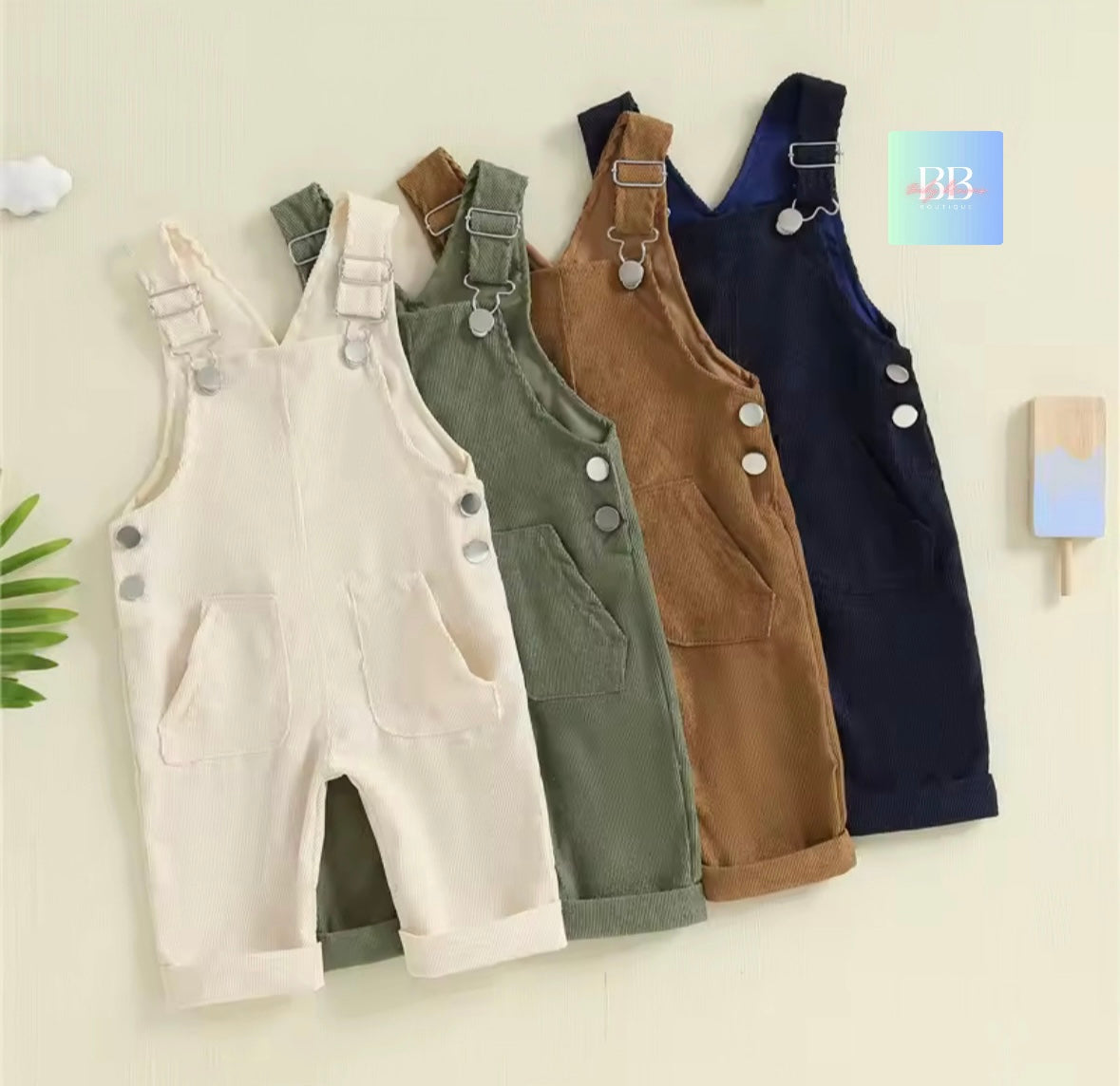 Four pairs of children's overalls in different colors on a light background