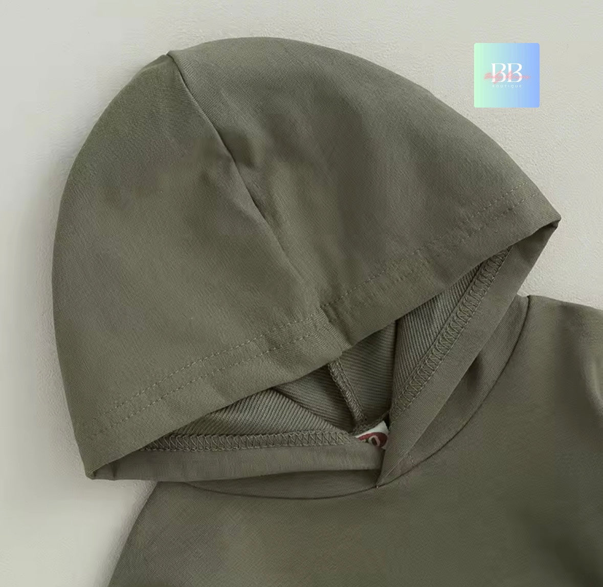 Green hooded garment on a light gray background