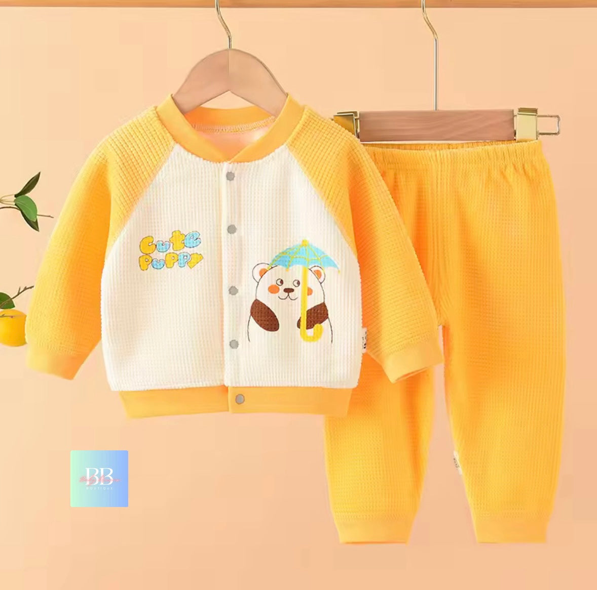 Yellow children's outfit with cartoon design on a beige background