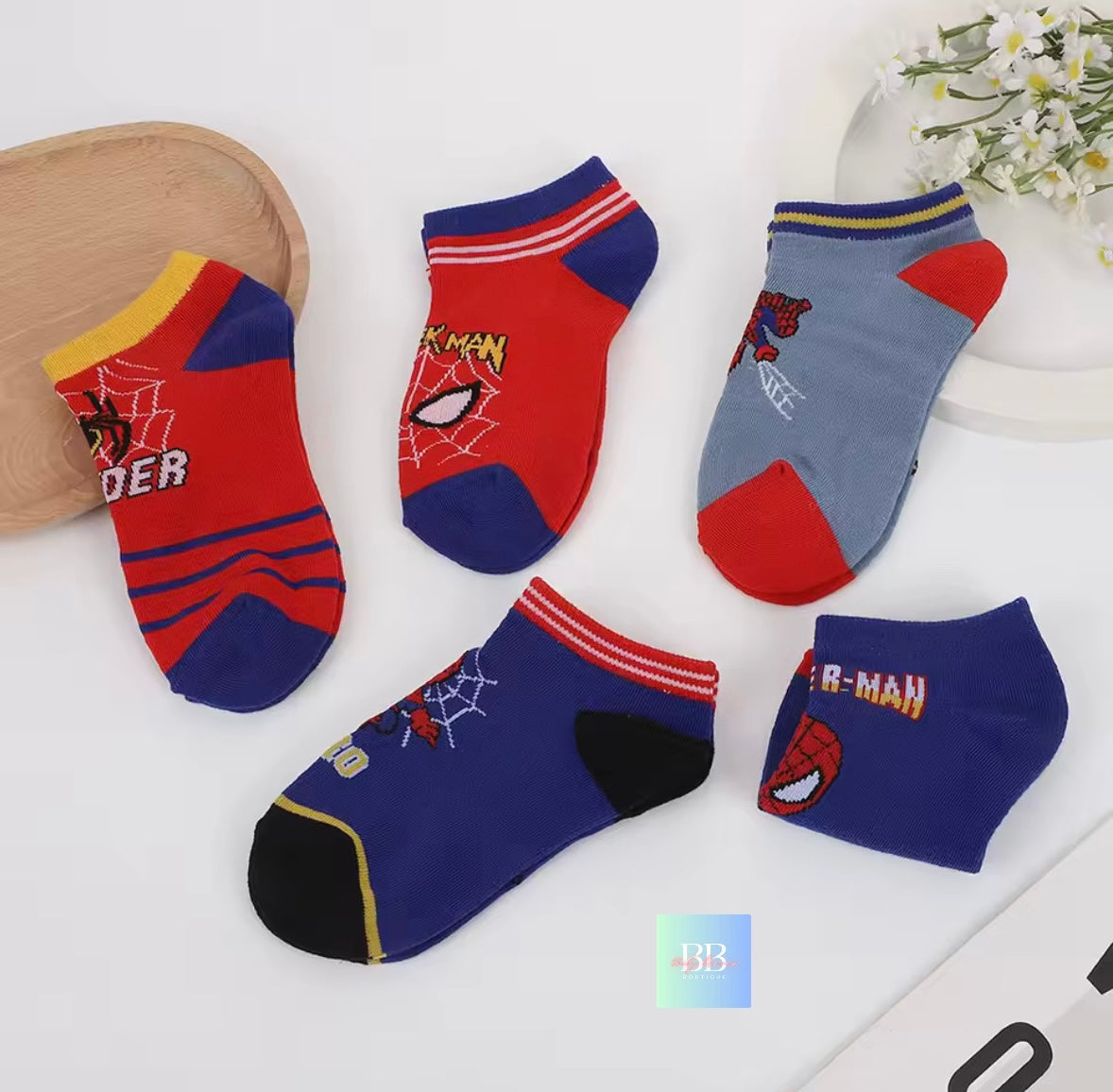 Set of colorful socks with Spider-Man design on a white surface.