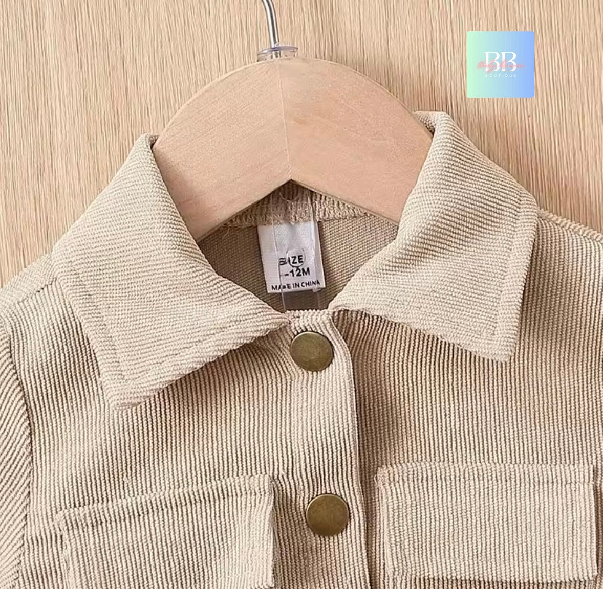 Beige corduroy jacket on a hanger with a visible brand logo in the corner.