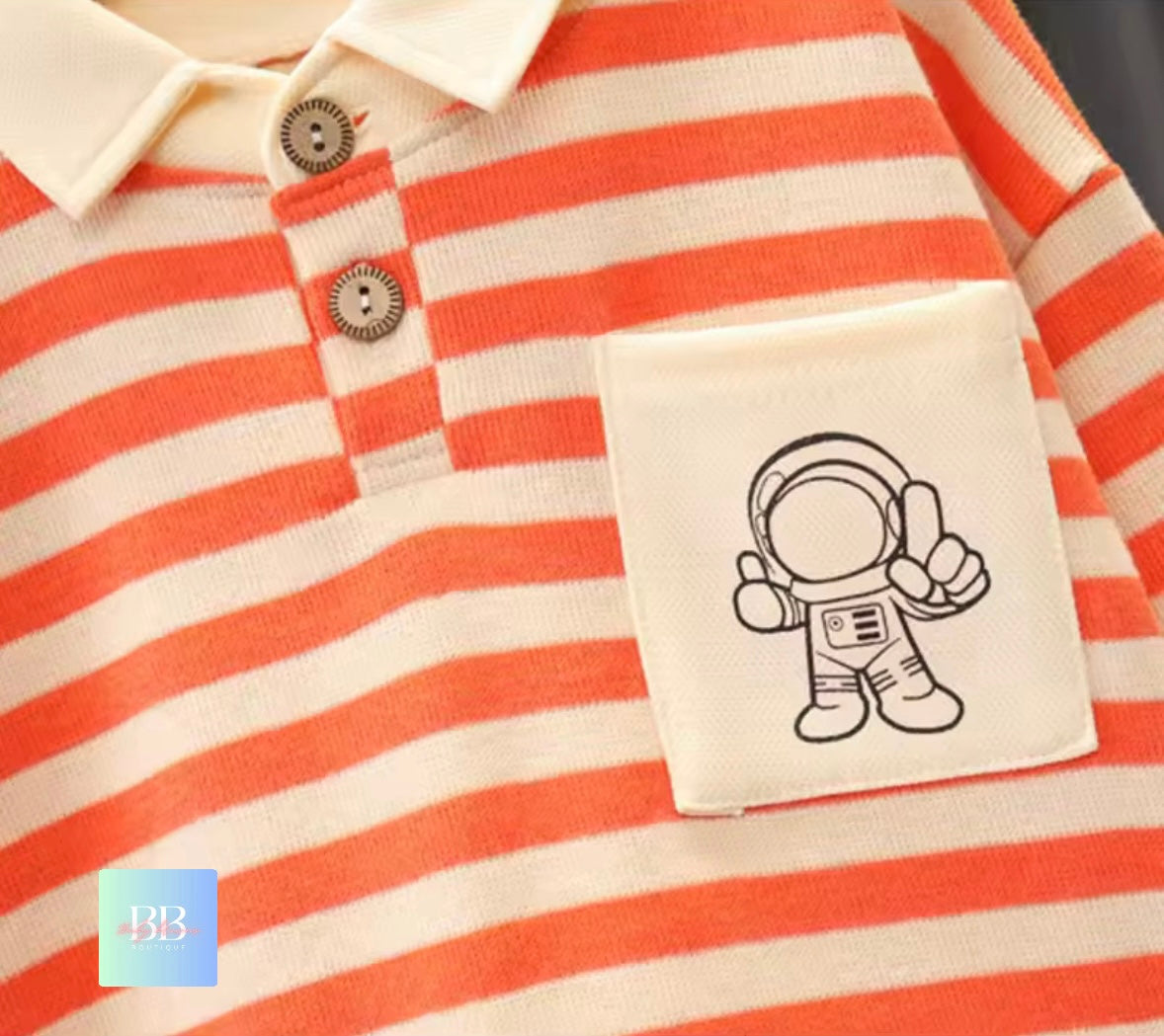 Orange and white striped shirt with an astronaut patch on a plain background