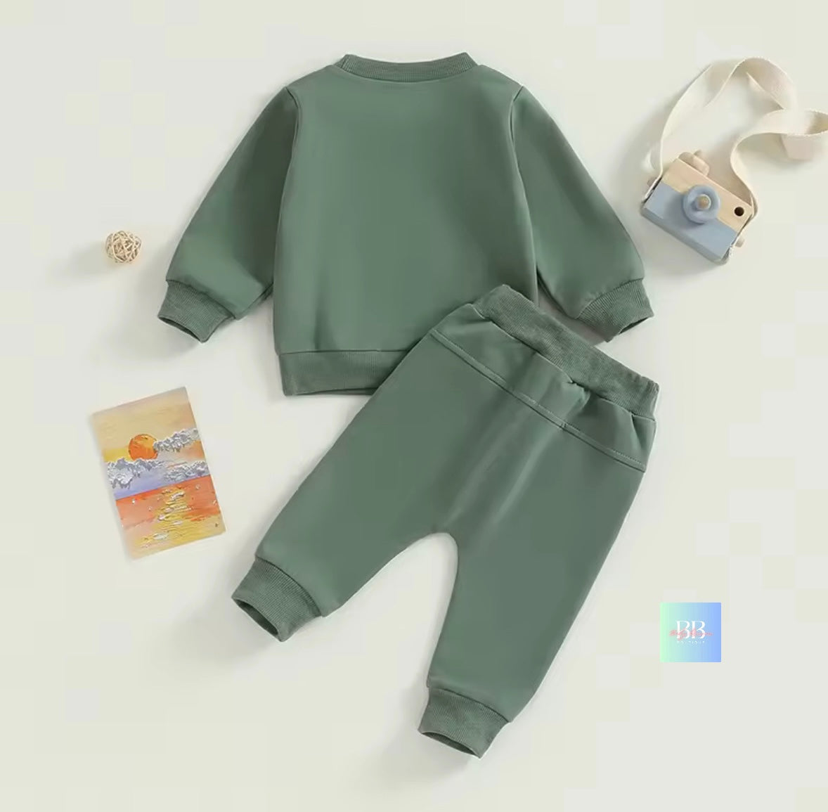 Green children's sweatshirt and pants set on a white background