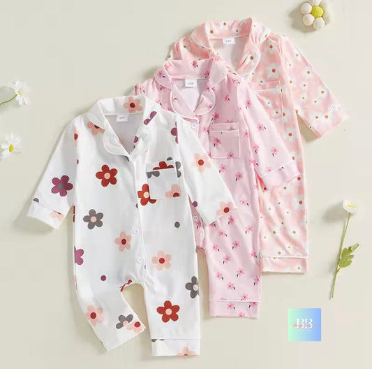 Two baby rompers with floral patterns on a light background