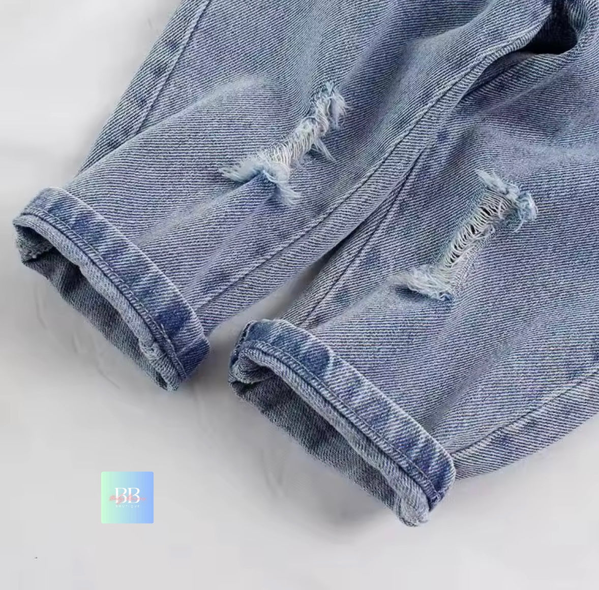 Ripped blue denim shorts on a white background