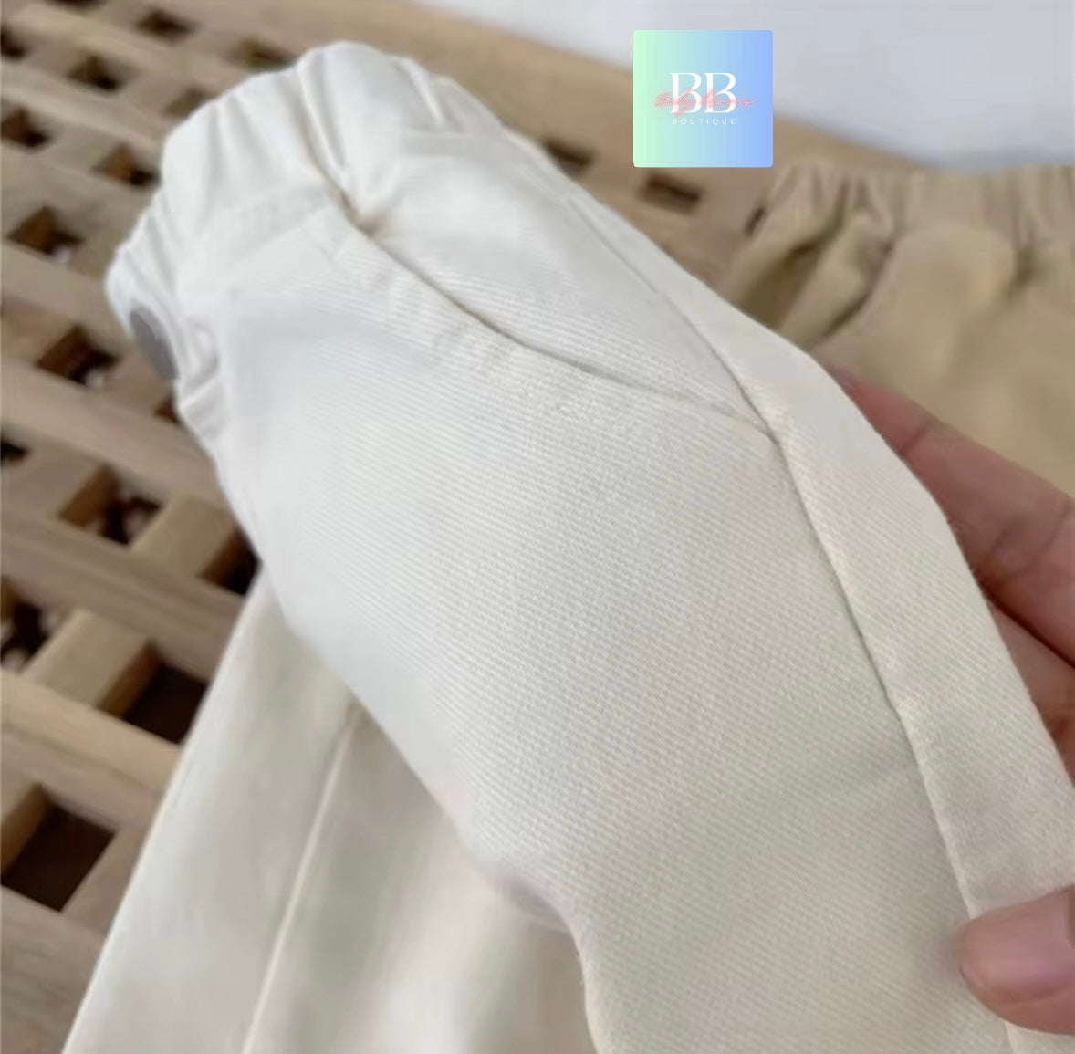 Close-up of a beige fabric roll held by a hand with a blurred background