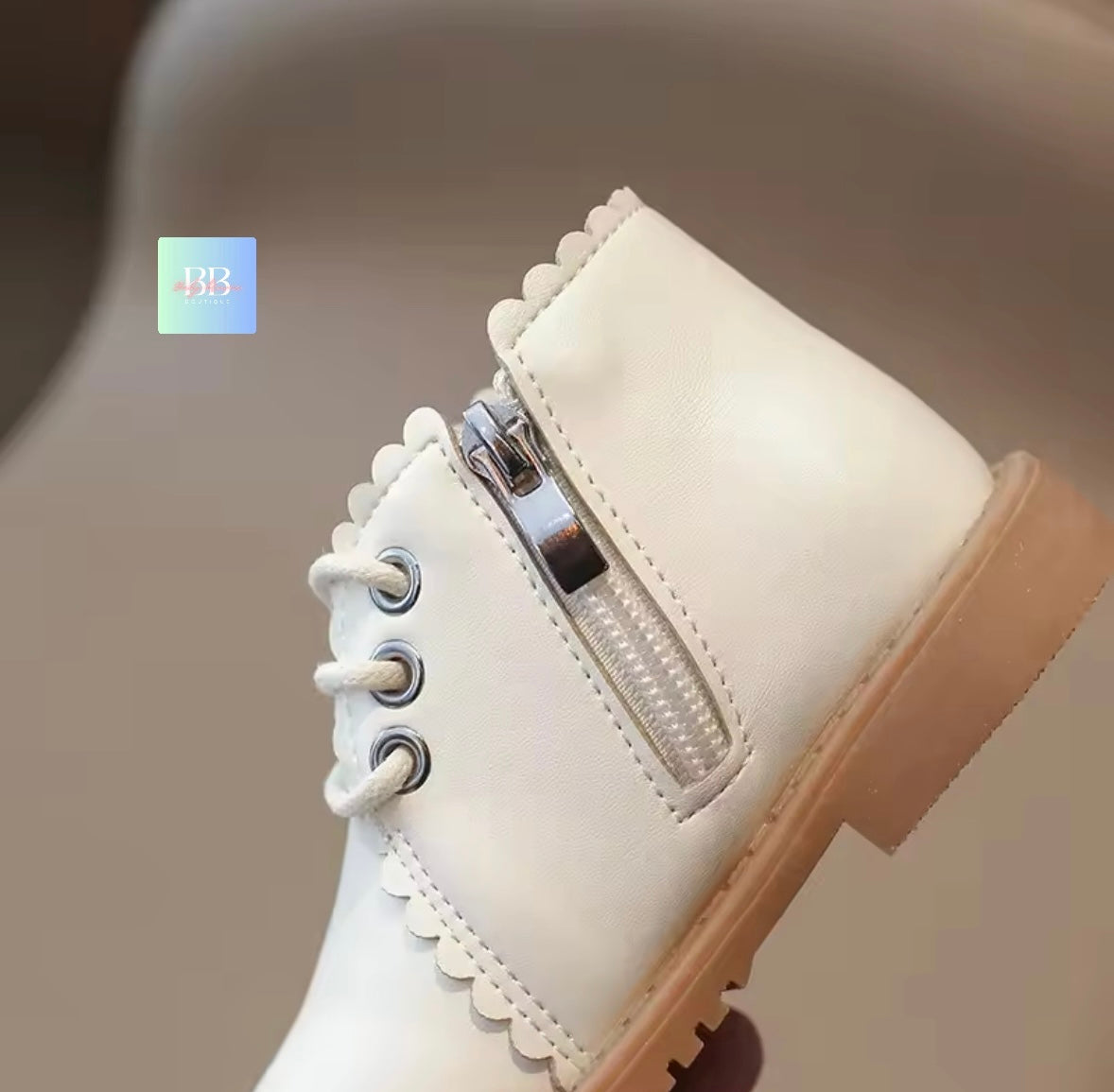 White boot with a zipper on a neutral background