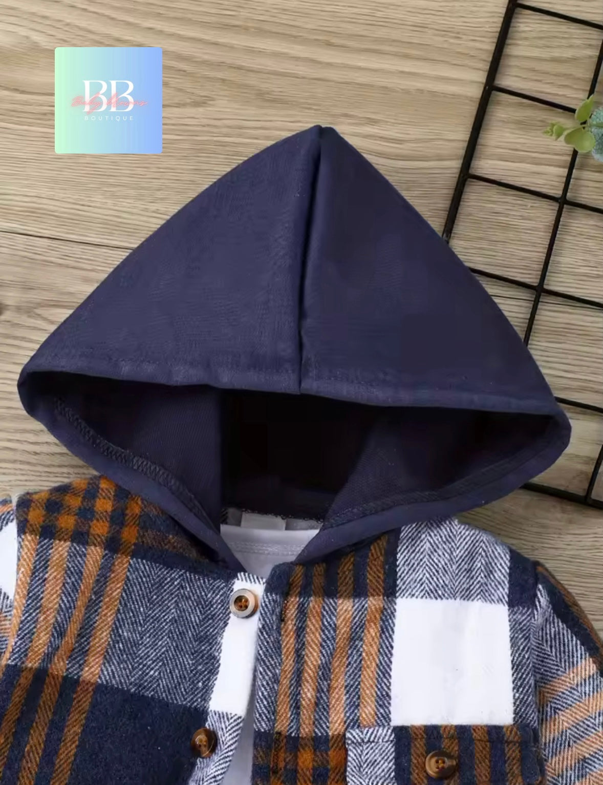 Navy blue hooded jacket with plaid pattern on a wooden surface