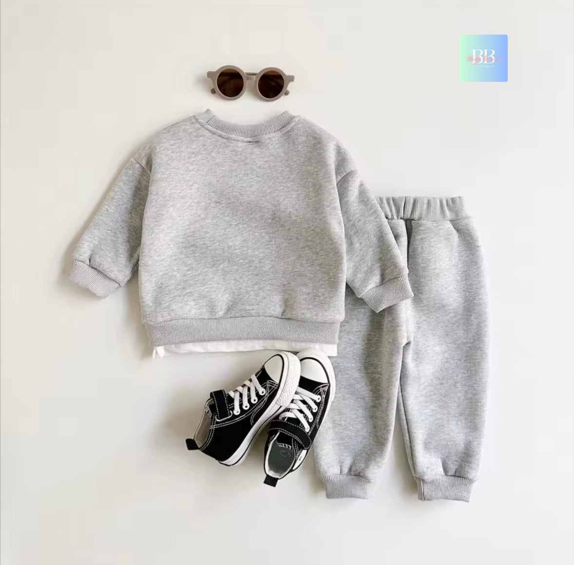 Gray sweatshirt and pants with black sneakers on a white background