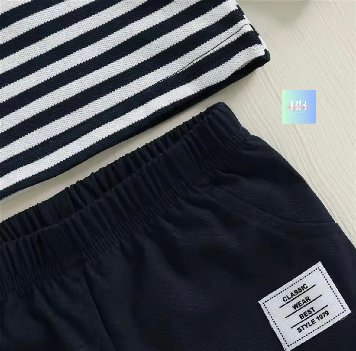 Black shorts with a striped fabric on a light wooden surface