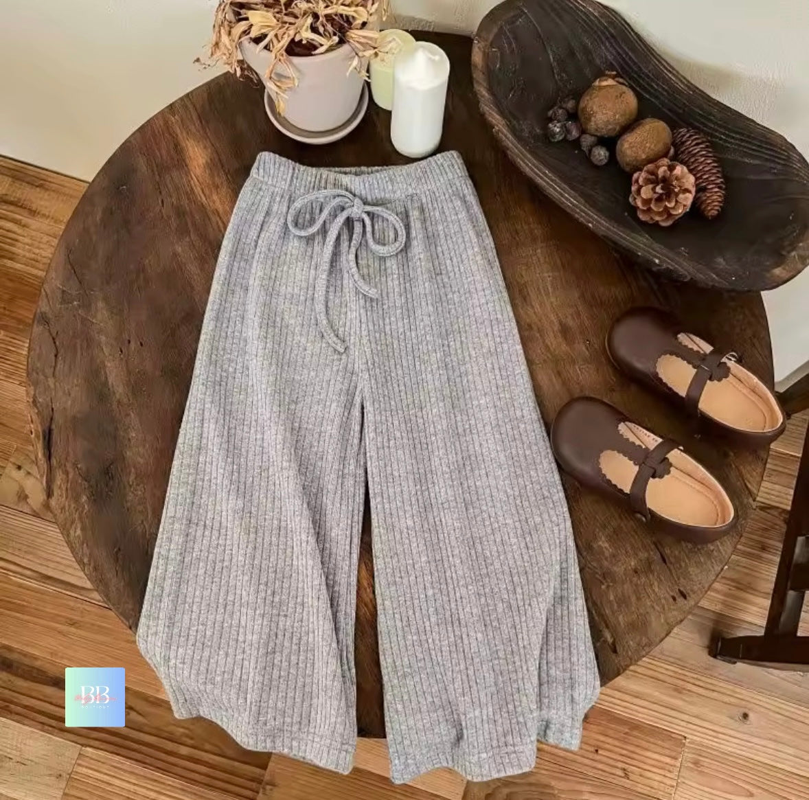 Gray pants on a wooden table with decorative items