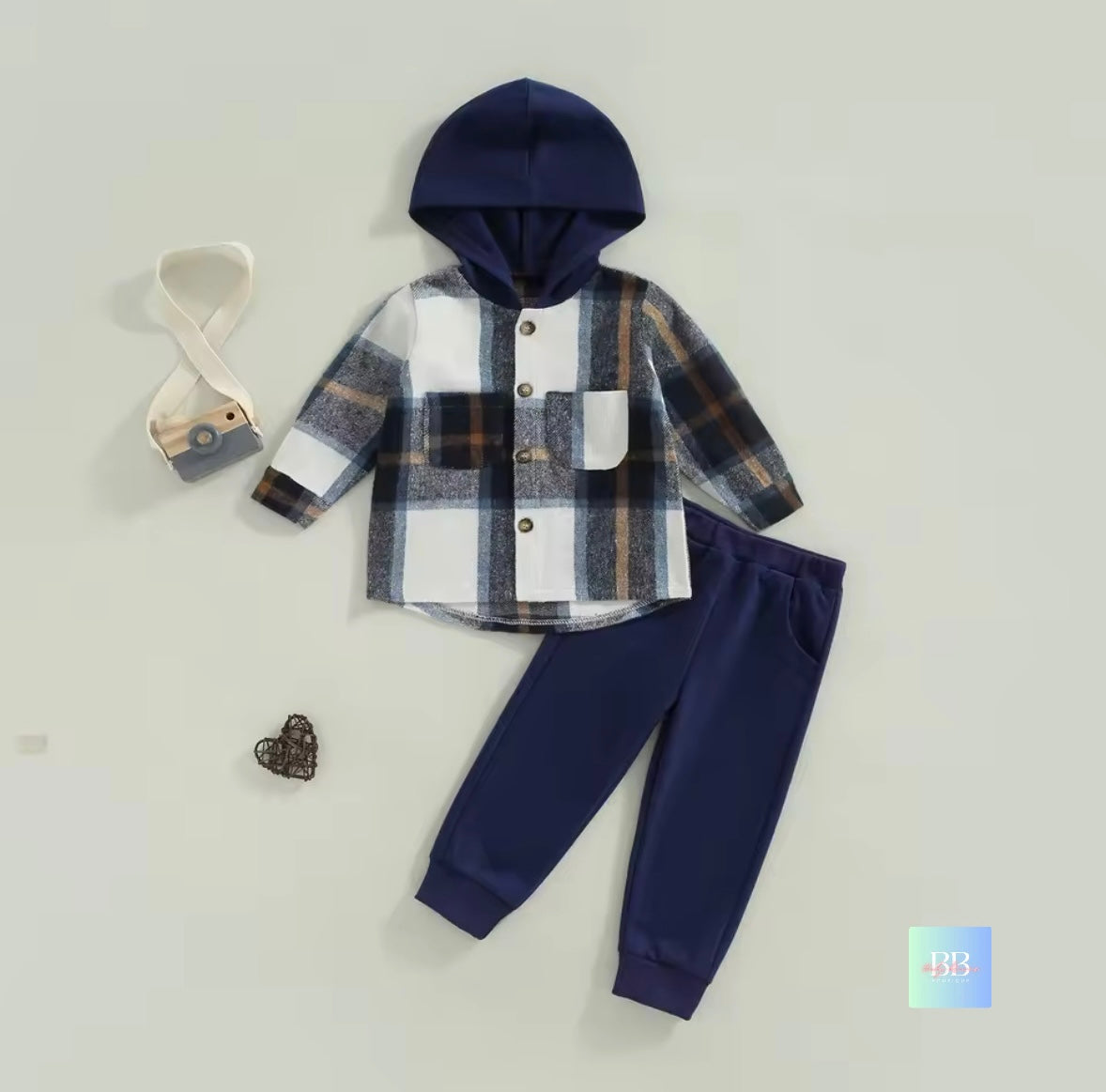Children's plaid shirt with hood and navy pants on a light gray background