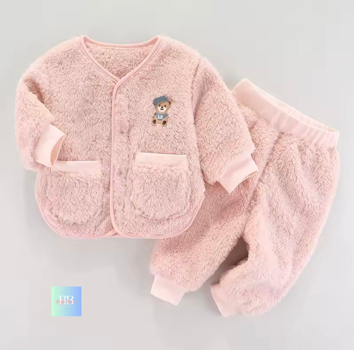 Pink baby outfit with a teddy bear design on a light gray background