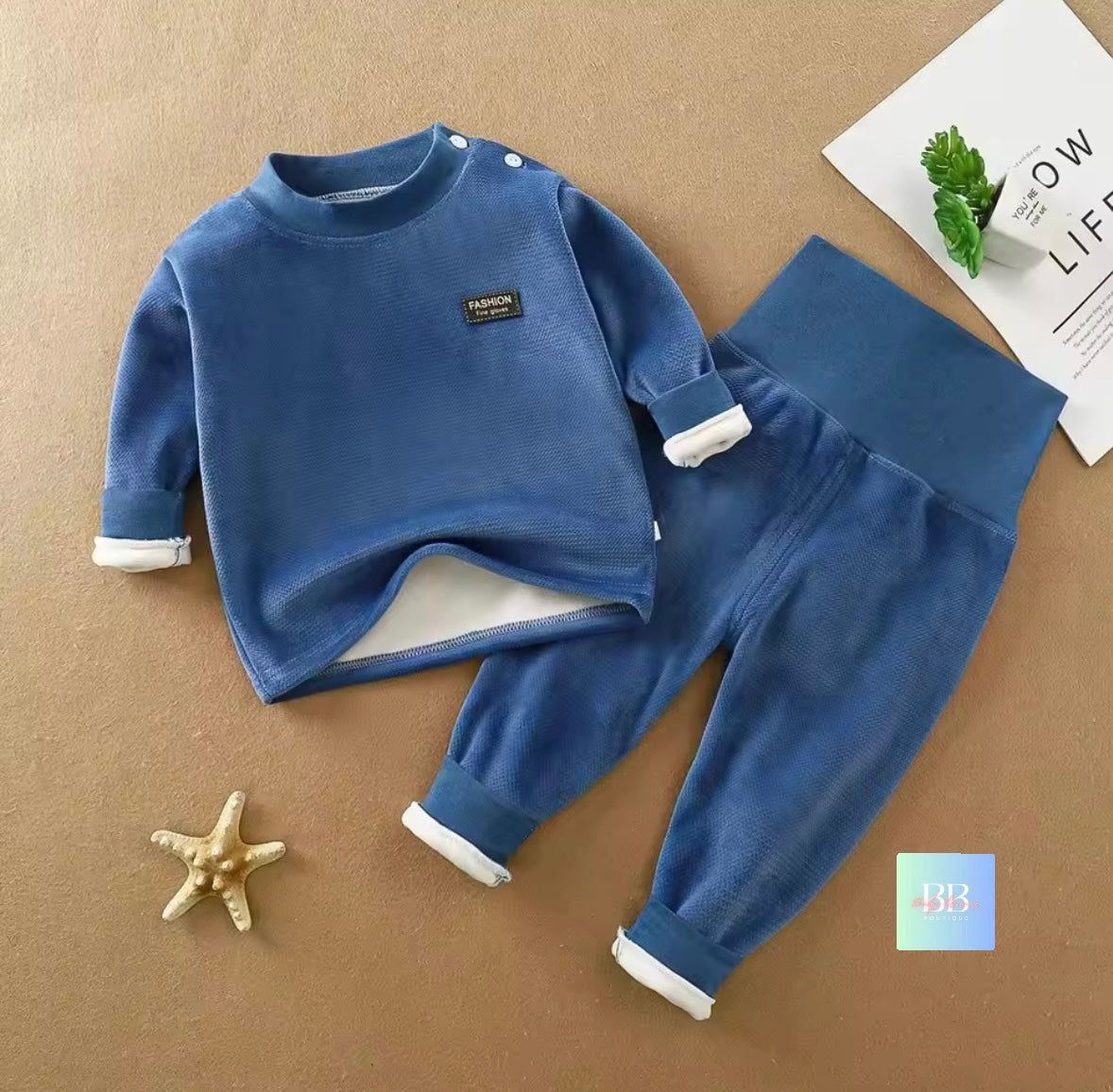 Blue children's outfit with a logo on a brown surface