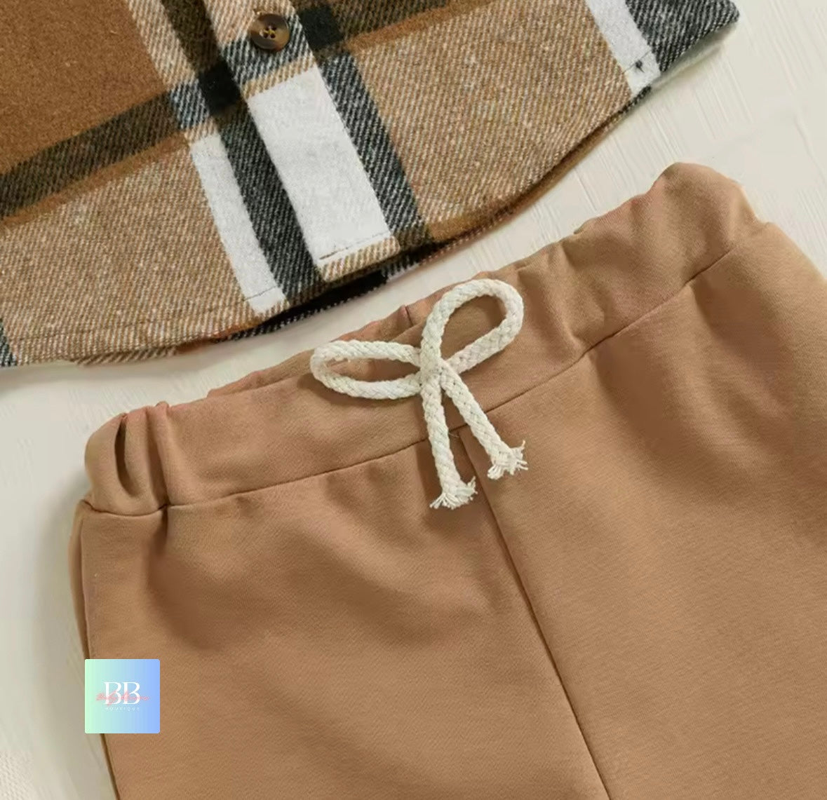 Brown plaid hat and pants with a white drawstring on a light background