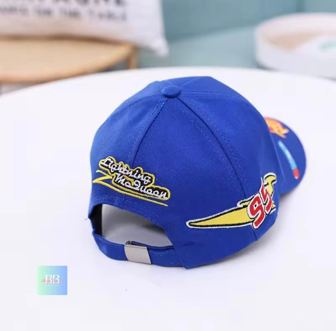 Blue cap with yellow and red text and graphics on a white surface