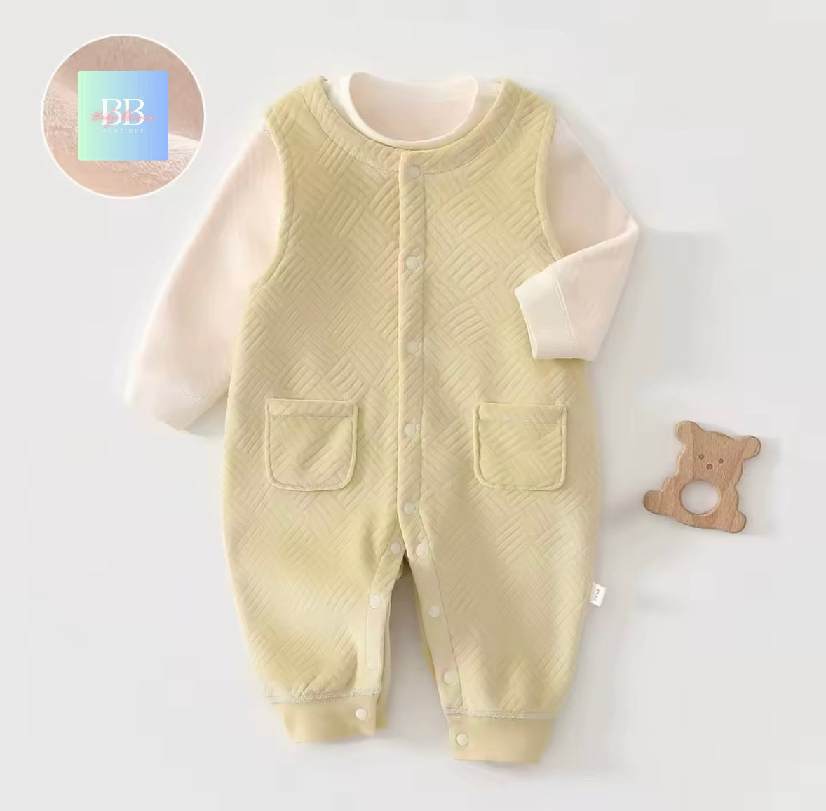 Baby romper with textured design on a light gray background