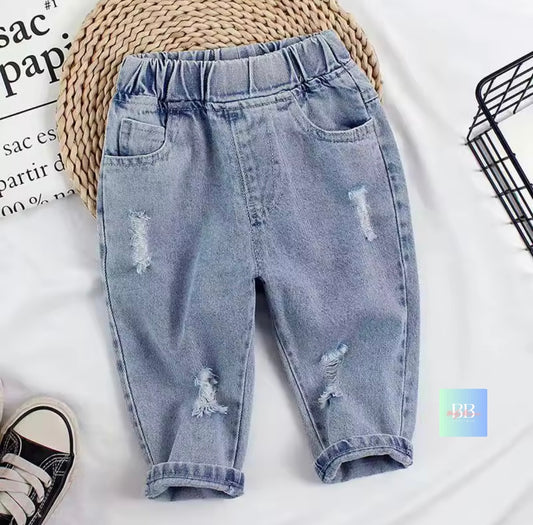 Light blue distressed jeans on a white background with a woven mat and black shoes.