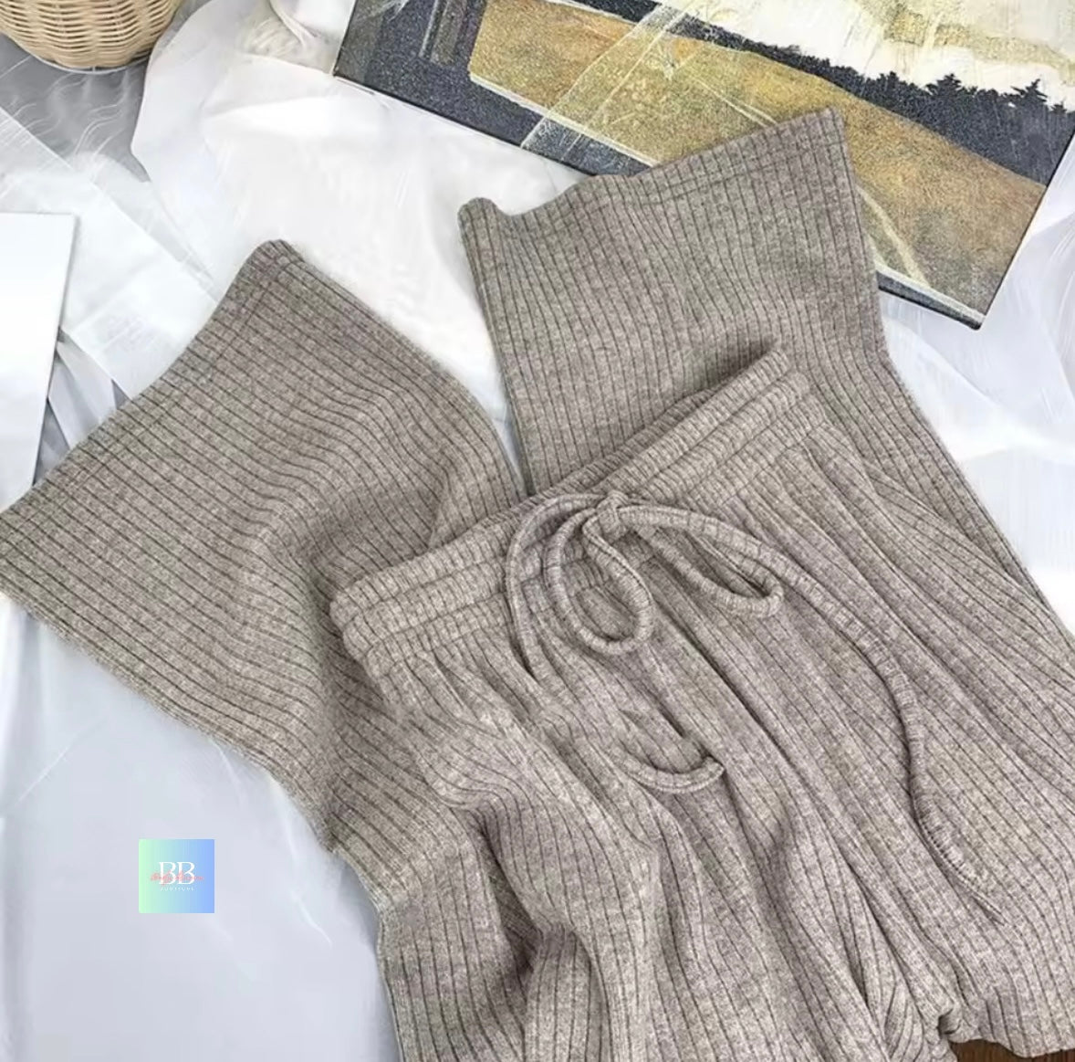 Gray ribbed knit pants with a drawstring waist on a white surface.