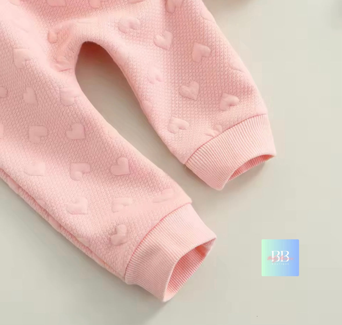 Pink baby pants with heart patterns on a light background