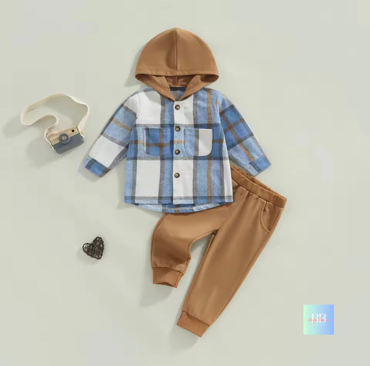 Children's outfit with plaid shirt and brown pants on a light gray background