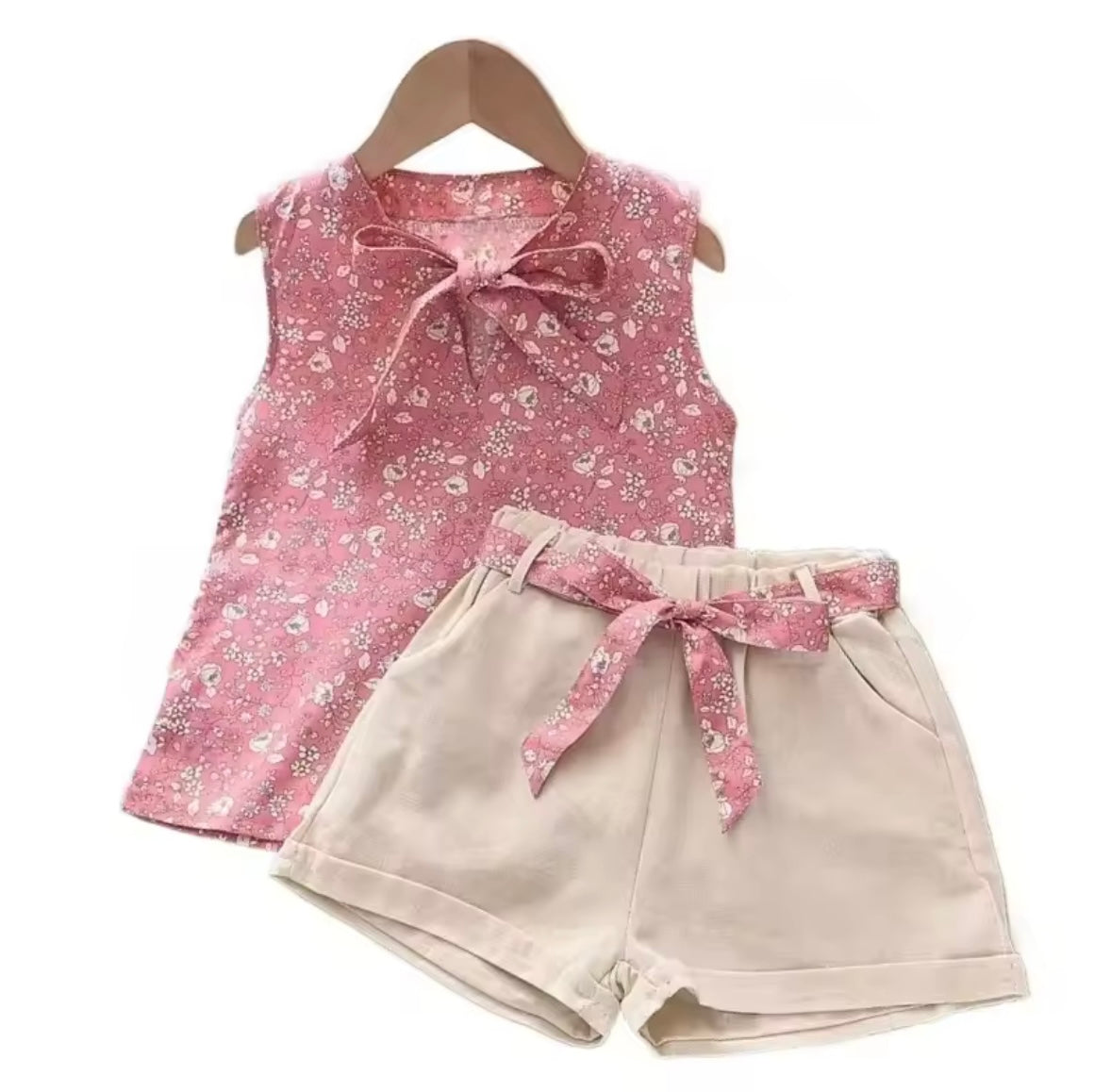 Pink floral top and beige shorts set on a white background