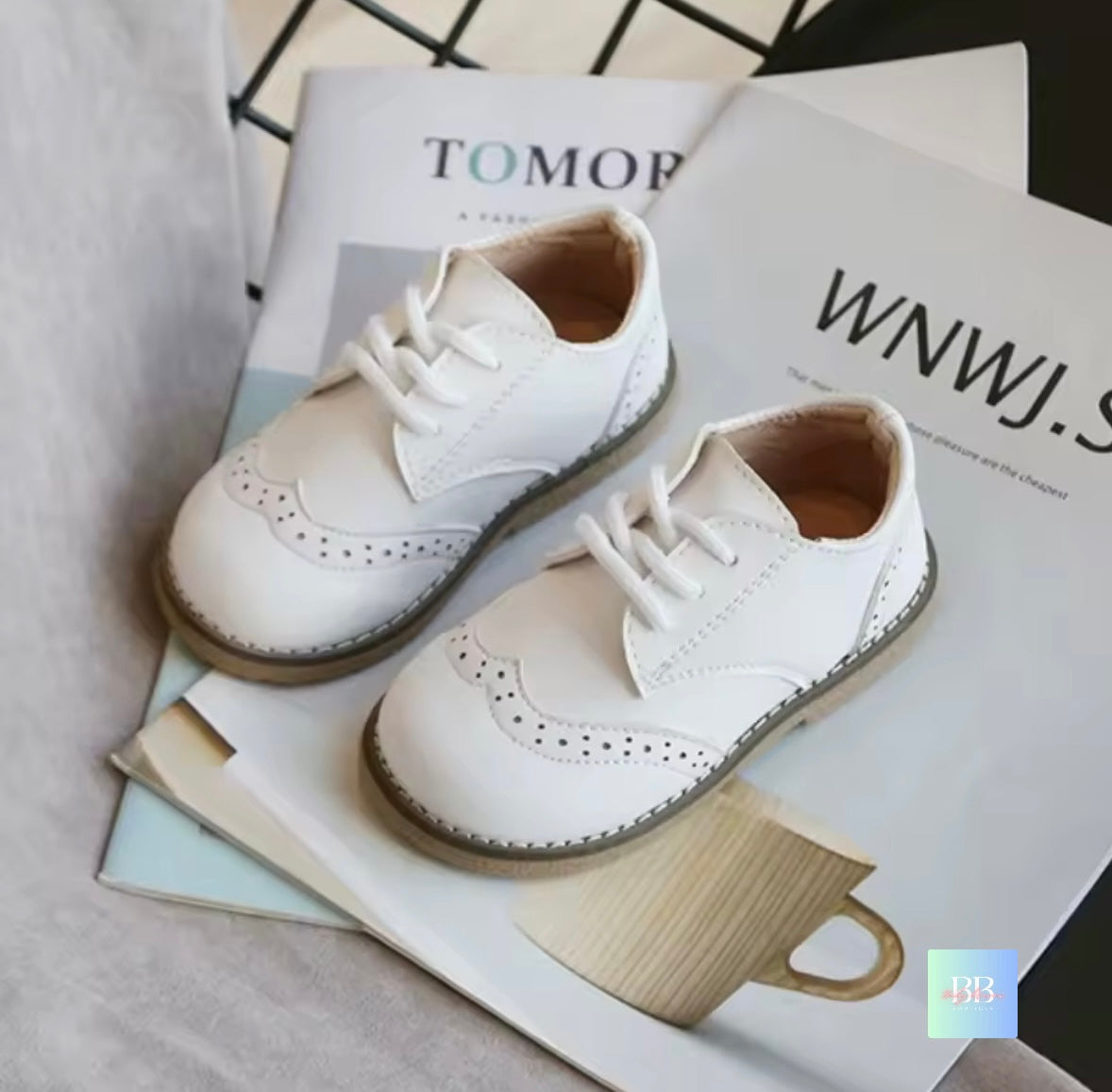 White shoes on top of a magazine with visible text