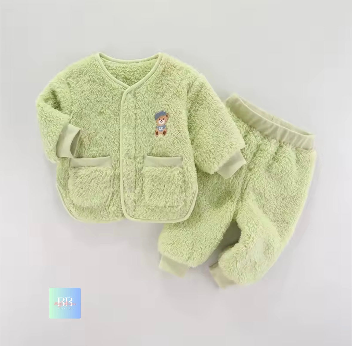 Light green baby outfit with a teddy bear design on a light gray background